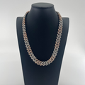 CB STORES two-tone silver and gold Cuban chain necklace displayed on a black stand against a plain white background.