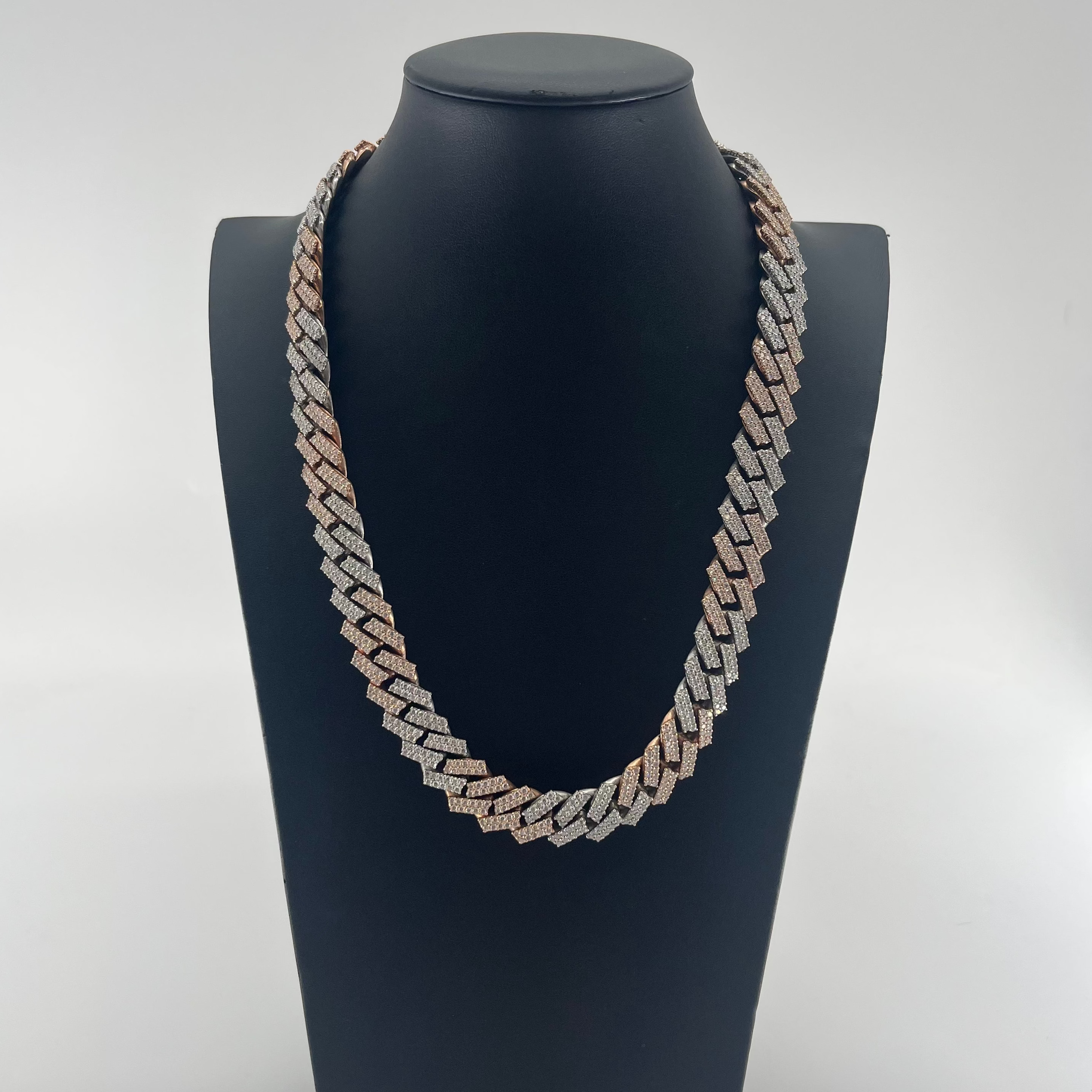 CB STORES two-tone silver and gold Cuban chain necklace displayed on a black stand against a plain white background.