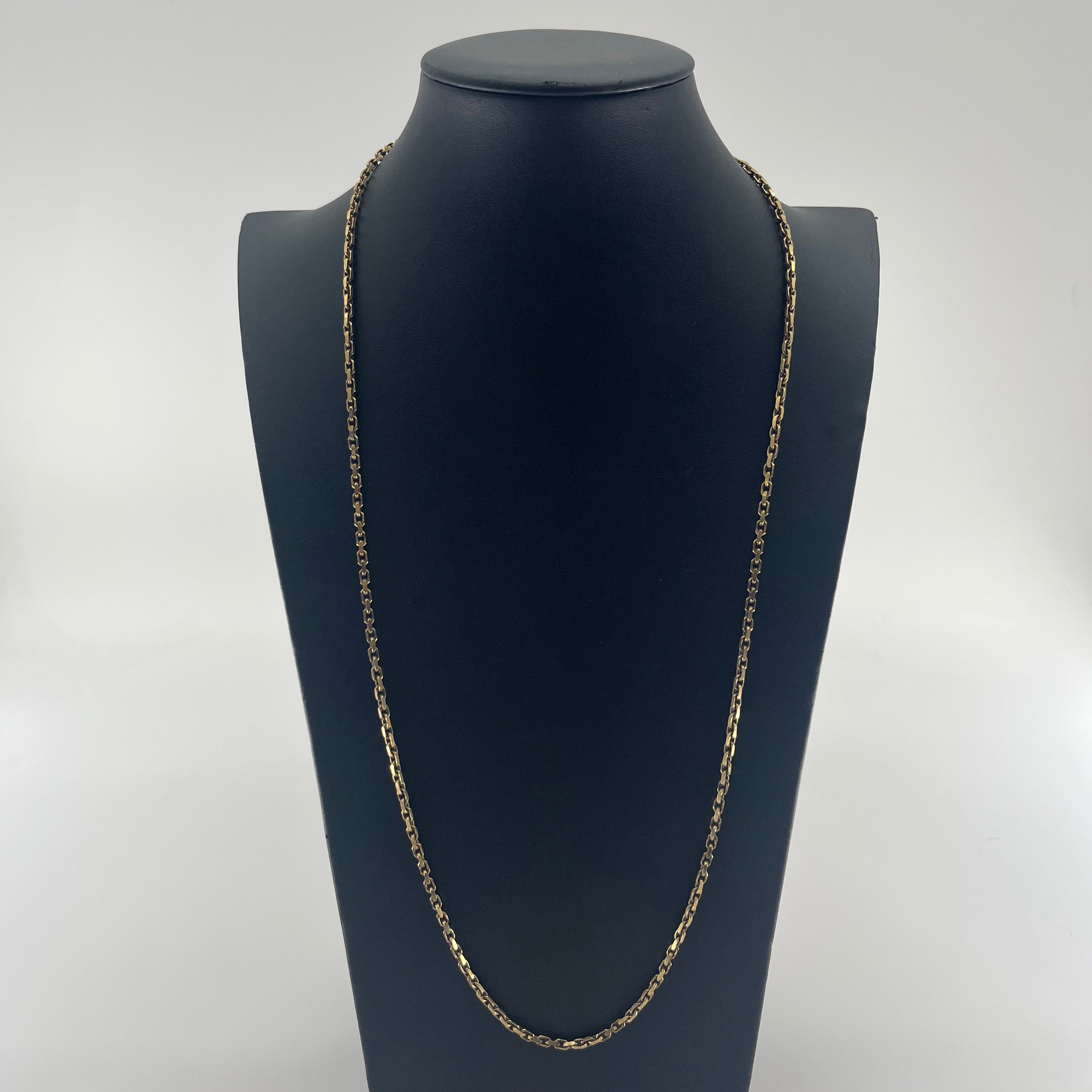 A yellow gold CB STORES 9ct anchor chain necklace displayed on a black mannequin bust against a plain white background.