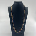 CB STORES yellow gold Figaro chain with oval links displayed on a black stand, set against a plain white background.