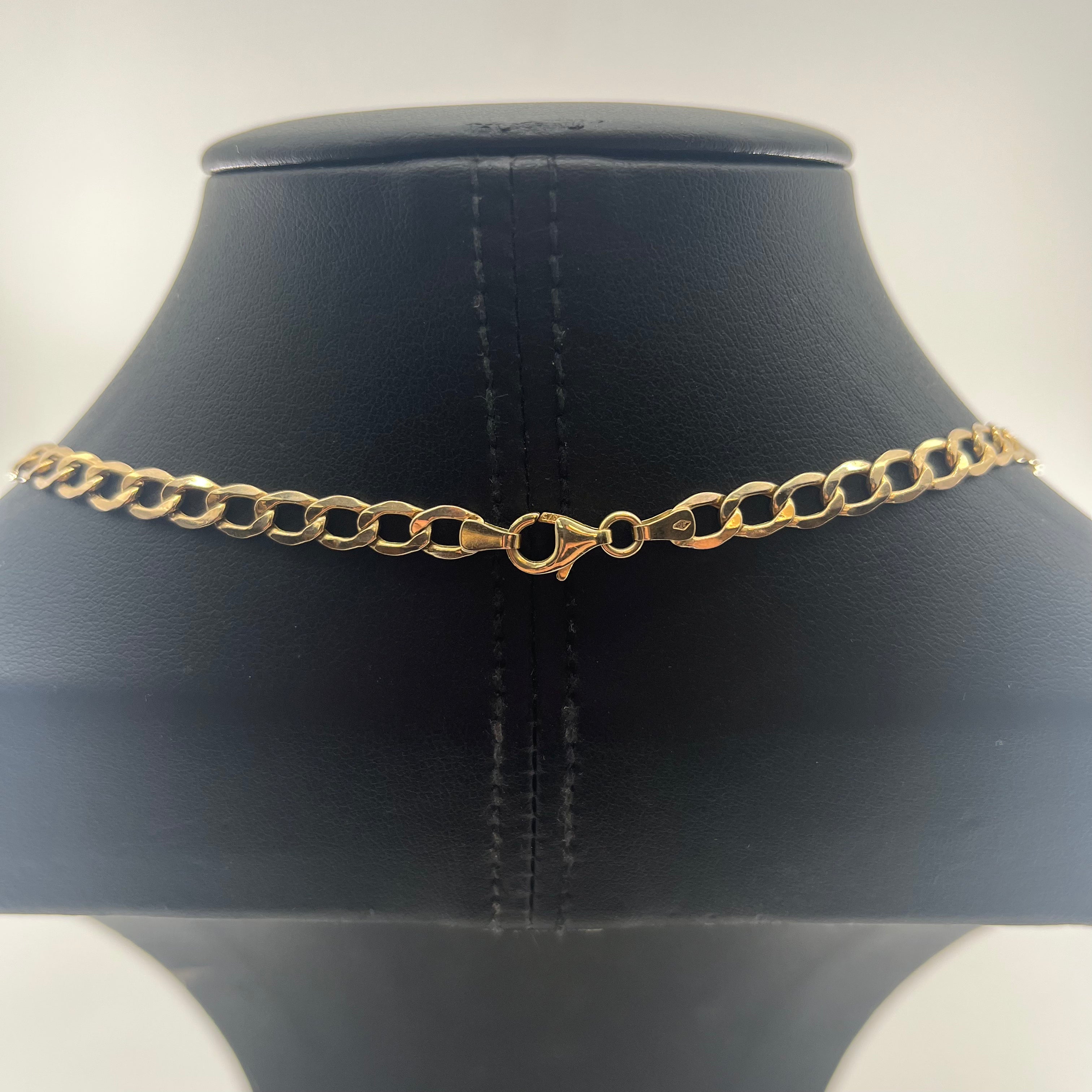 CB STORES 9ct yellow gold curb chain necklace shown from the back on a black leather stand, displaying the lobster clasp.