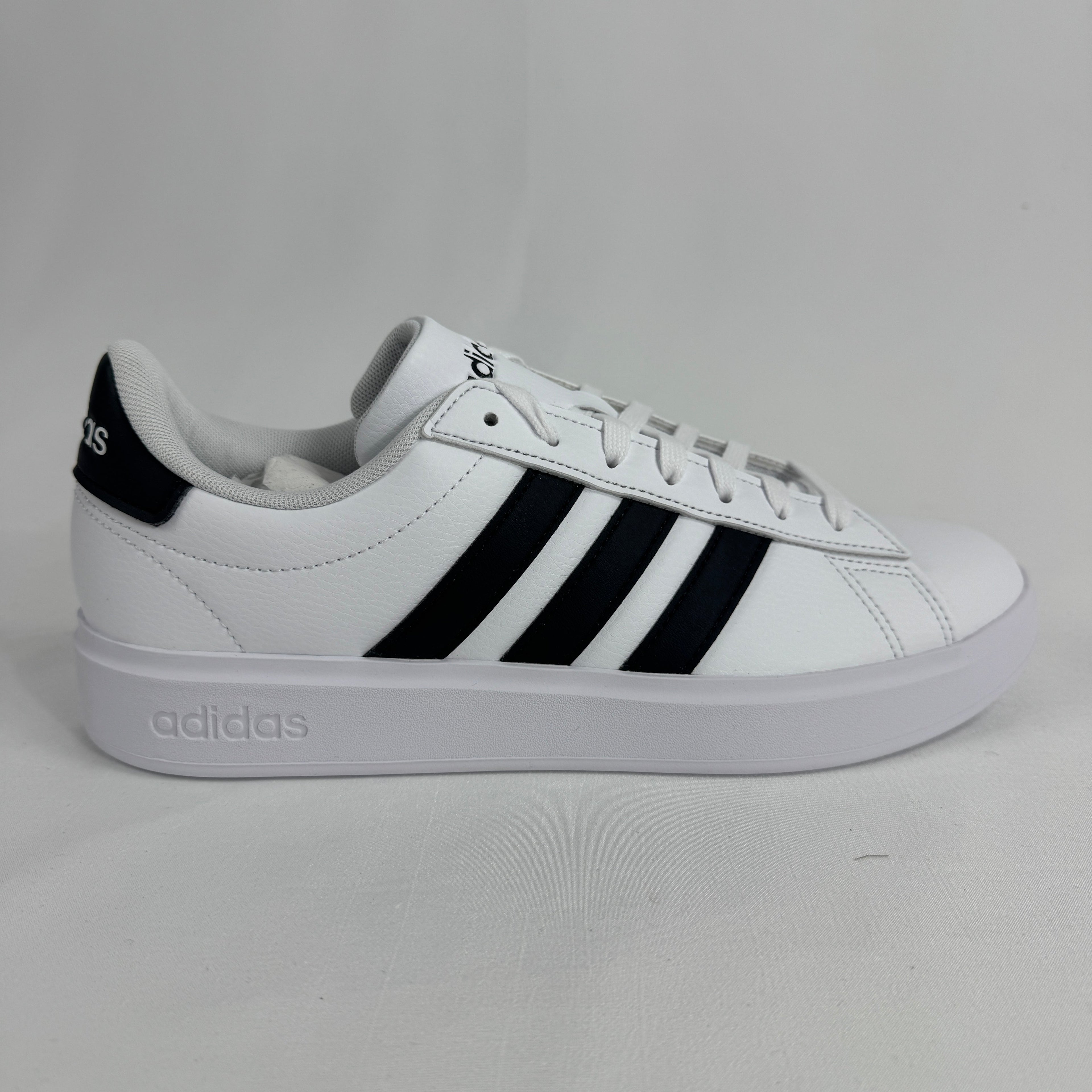 The Adidas Grand Court 2.0 is a casual court-inspired sneaker with a smooth synthetic or leather-like upper, soft