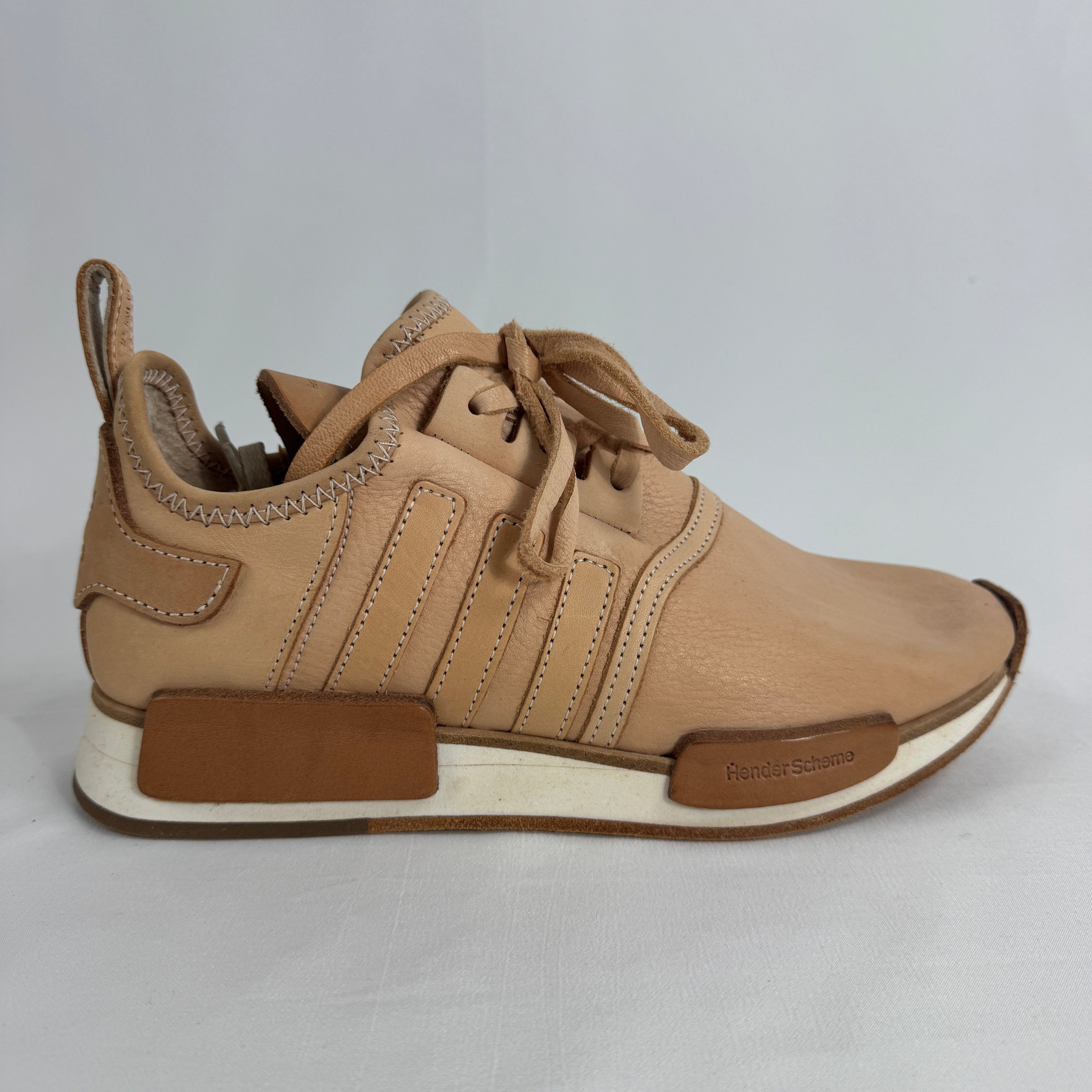 The Adidas x Hender Scheme NMD R1 is a premium collaboration that reimagines the iconic NMD with handcrafted natural leather