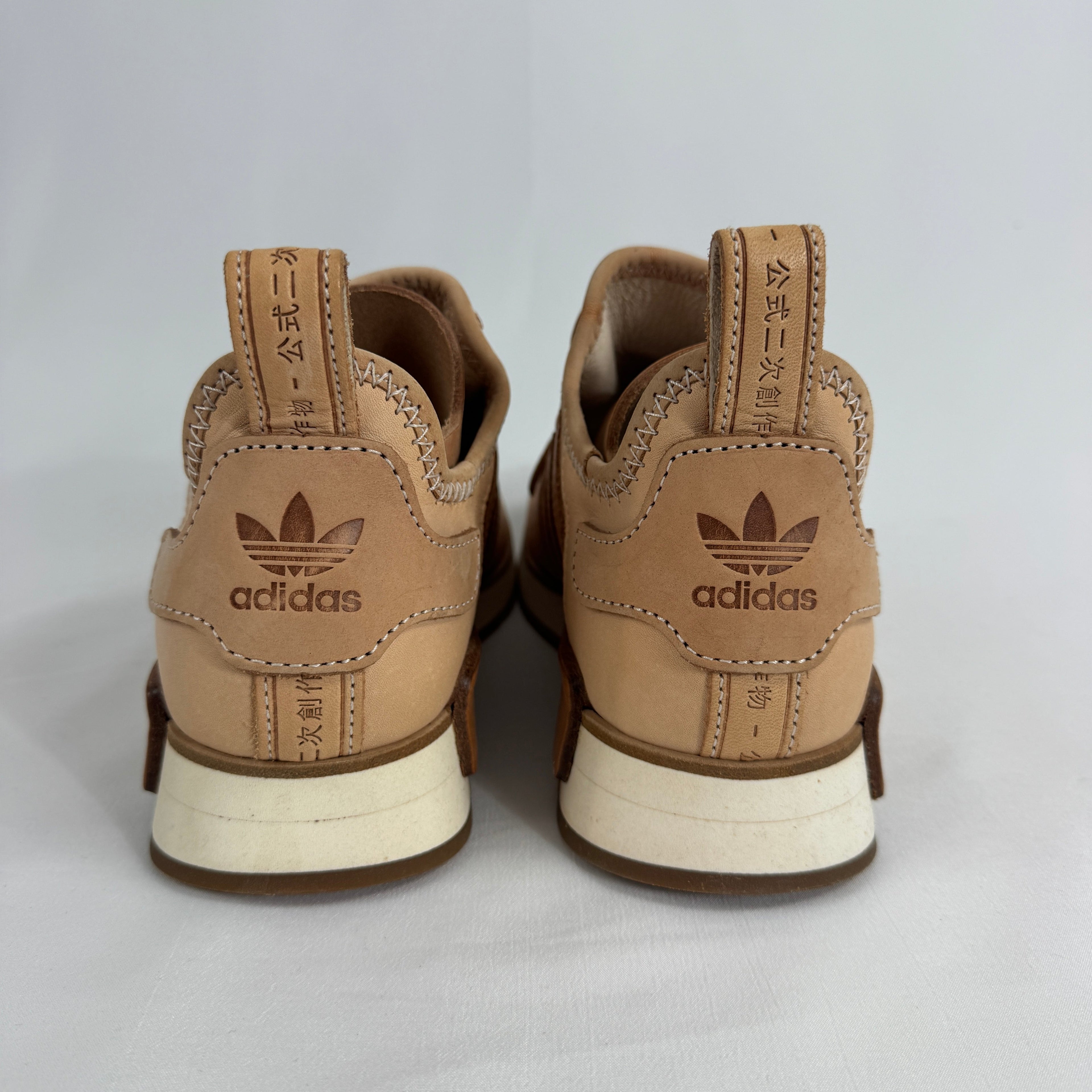 The Adidas x Hender Scheme NMD R1 is a premium collaboration that reimagines the iconic NMD with handcrafted natural leather