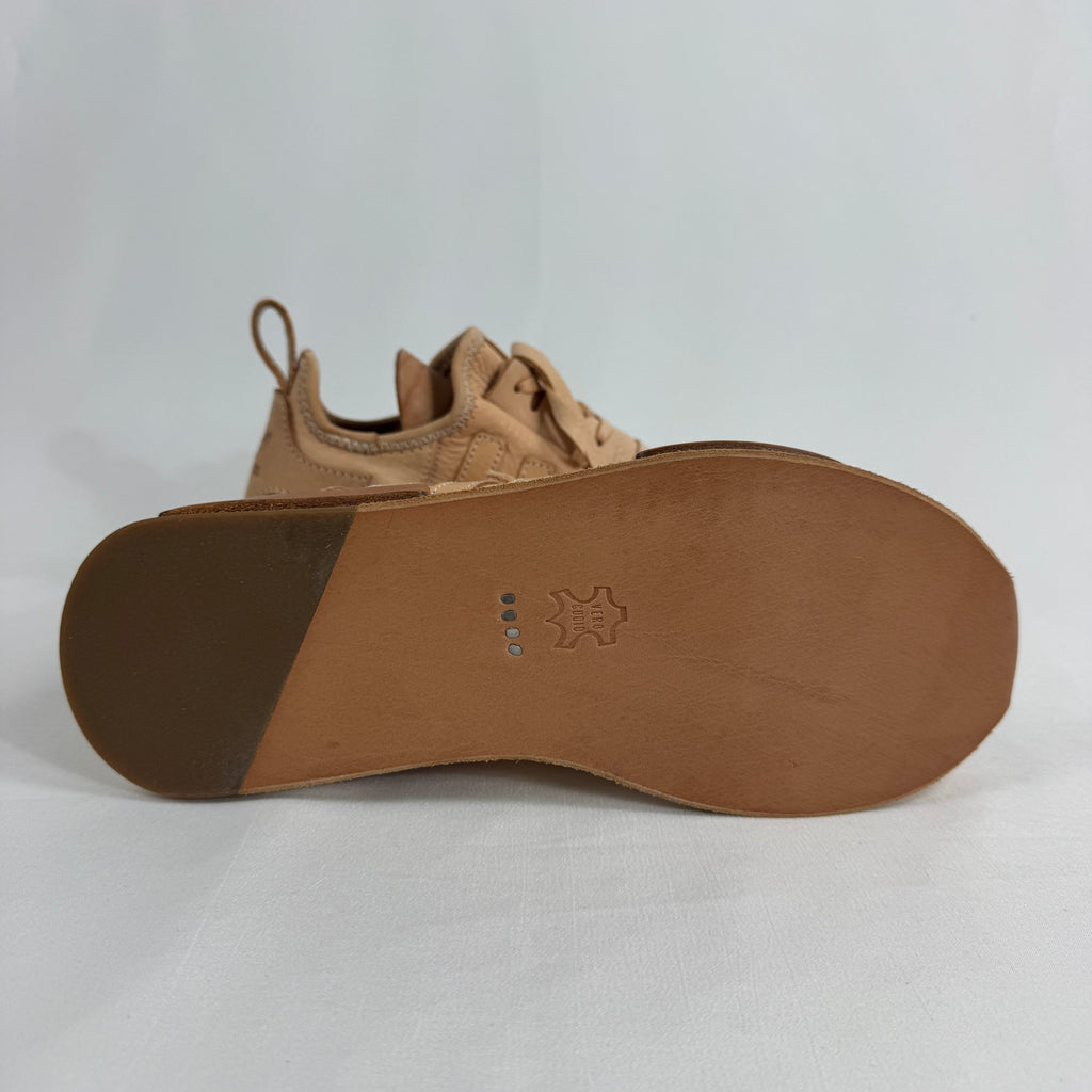 The Adidas x Hender Scheme NMD R1 is a premium collaboration that reimagines the iconic NMD with handcrafted natural leather