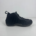 A black Nike basketball trainer with wavy detail, textured sole, Zoom Air cushioning and heel pull tab on a white background.