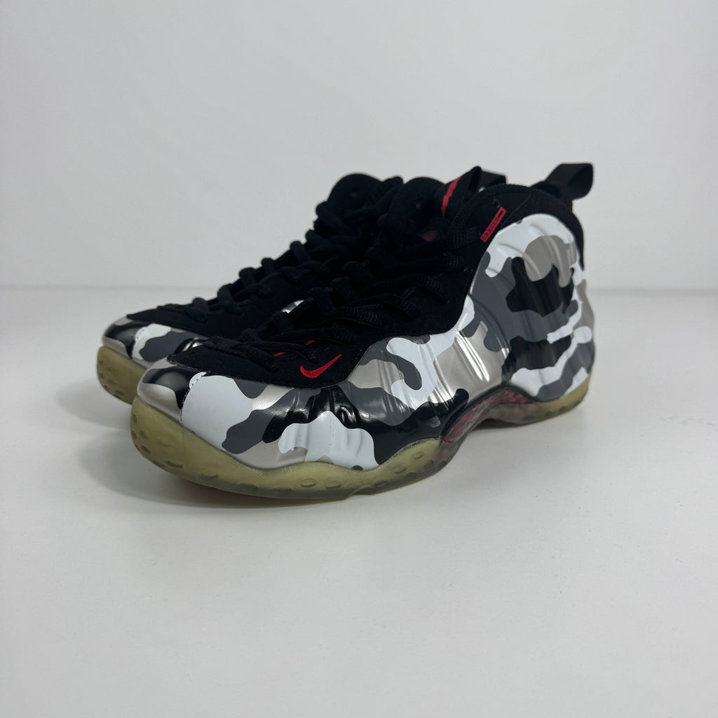 Nike Air Foamposite One PRM trainers in black, white and grey camo with translucent yellow soles on a plain white background.