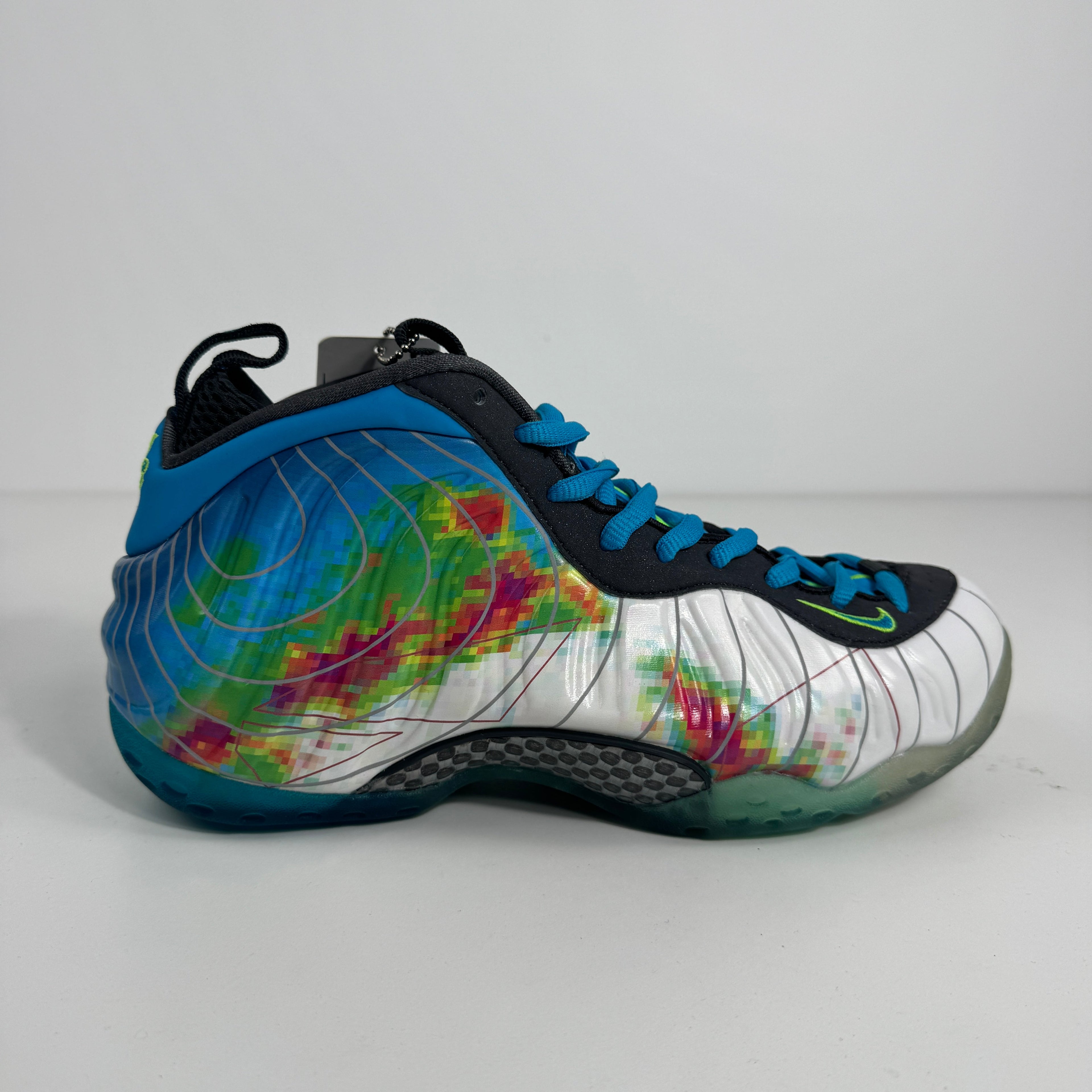 Nike trainers with a white base, blue laces, and bold multicoloured abstract patterns in green, pink and blue.