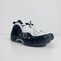 The Nike Air Foamposite One Concord UK 7 features a shiny black molded upper paired with stark white leather trim along the
