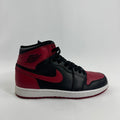 Side view of a black and red Nike Air Jordan trainer with the swoosh and wings emblem, set against a plain white background.