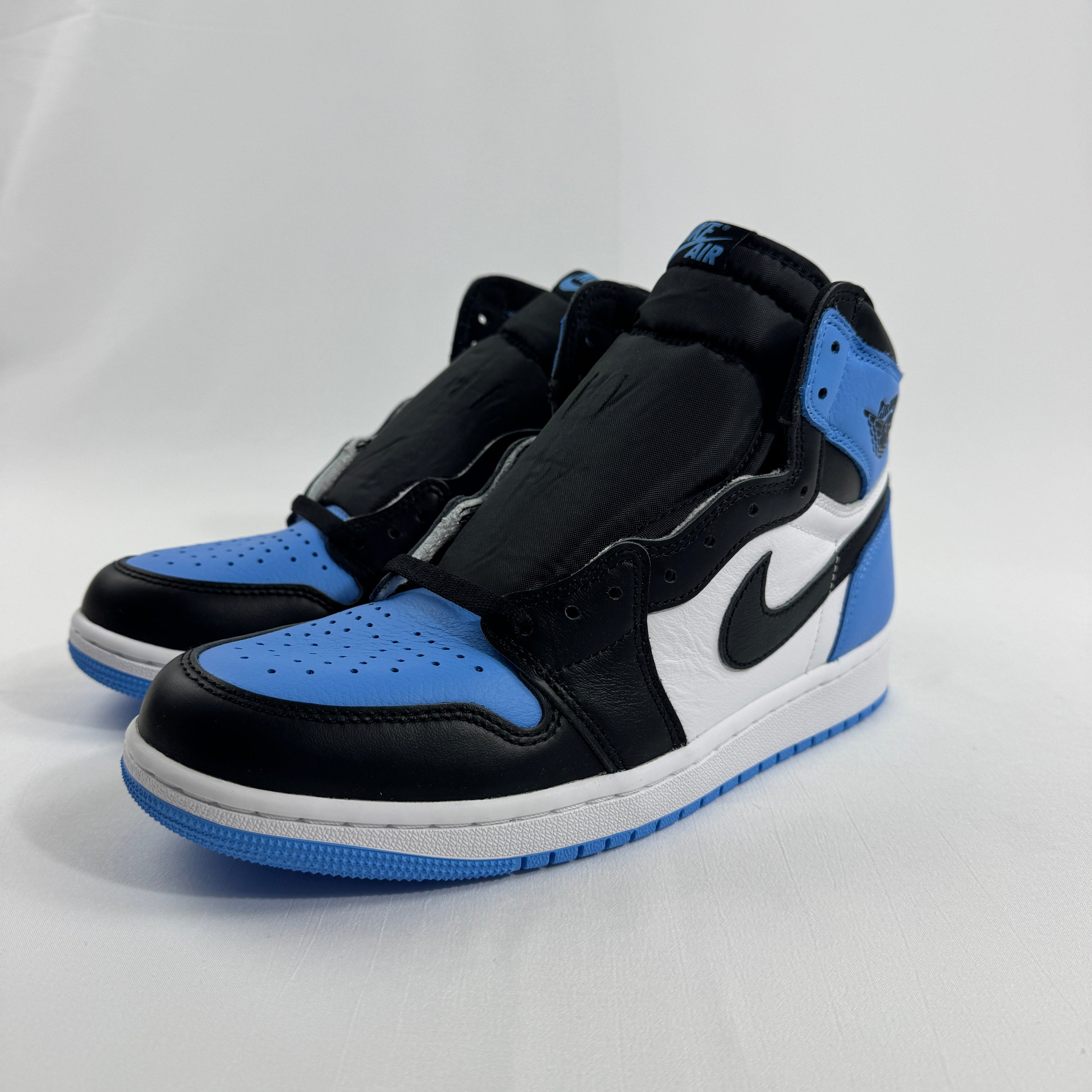 Nike Air Jordan 1 Retro High OG trainers in blue, white and black, laceless, with side branding, on a white background.