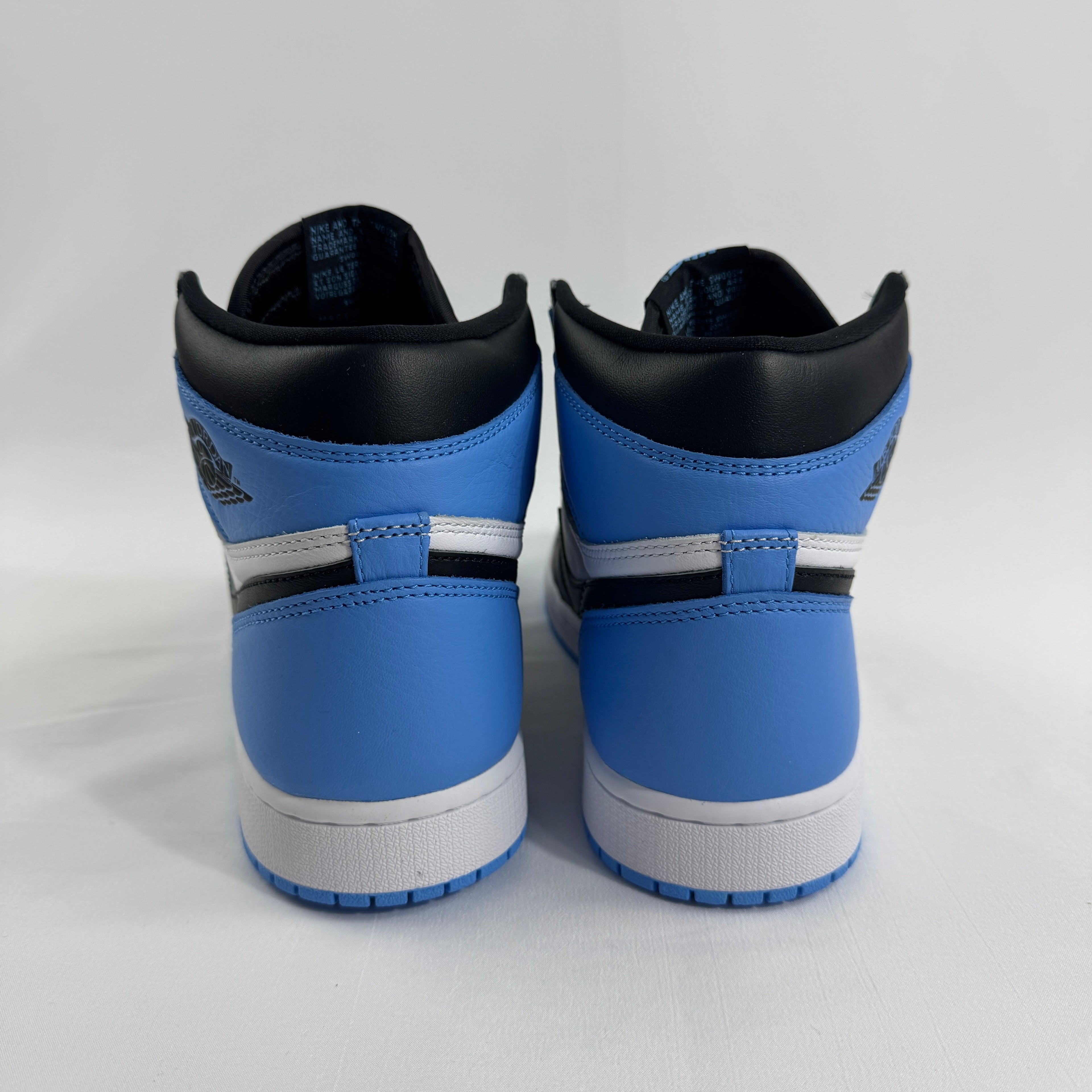 Rear view of Nike high-top trainers in blue, white and black against a plain white background.