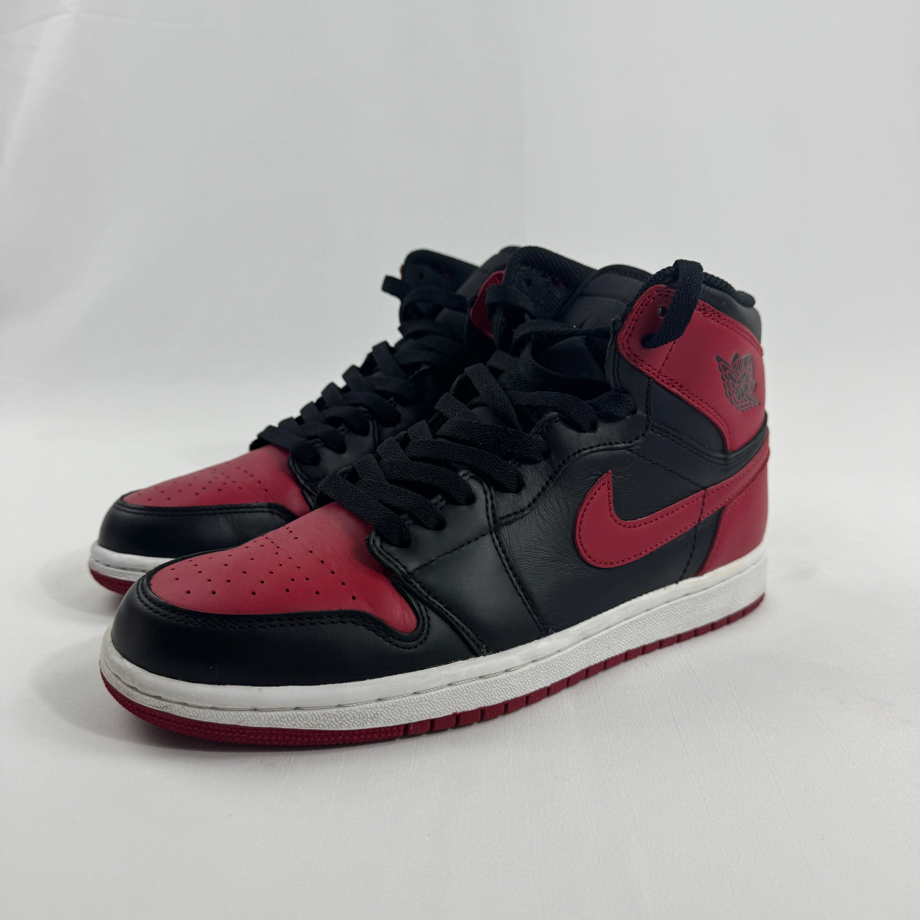 NIKE Air Jordan 1 trainers in black and red leather with white midsoles and black laces, shown on a plain white background.