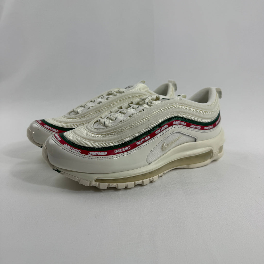 NIKE Air Max 97 Undefeated Sail trainers with cream soles and red, black and green accents on a plain white background.