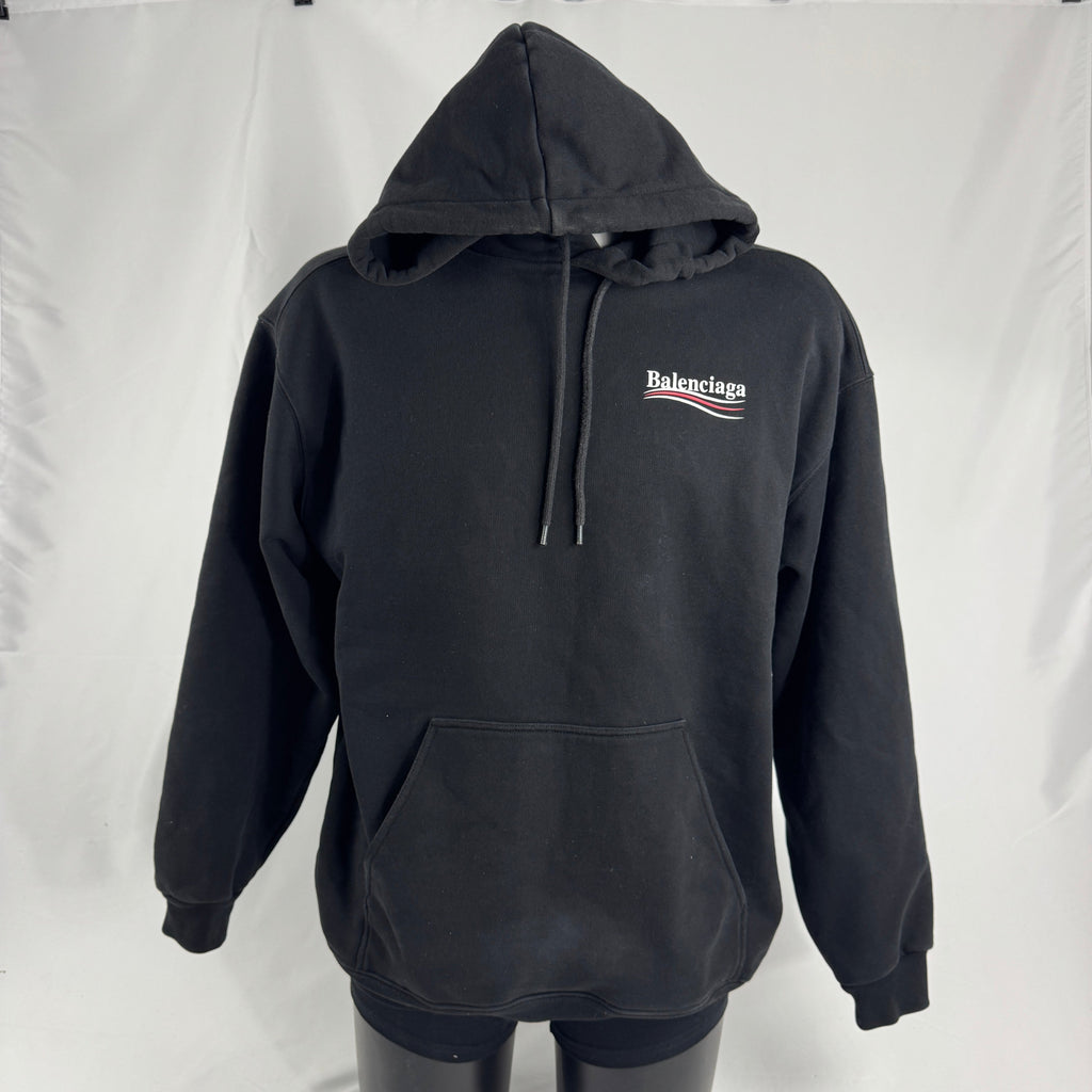 The Balenciaga Political Campaign Hoodie is a heavyweight cotton hoodie featuring the brand’s satirical “campaign” logo