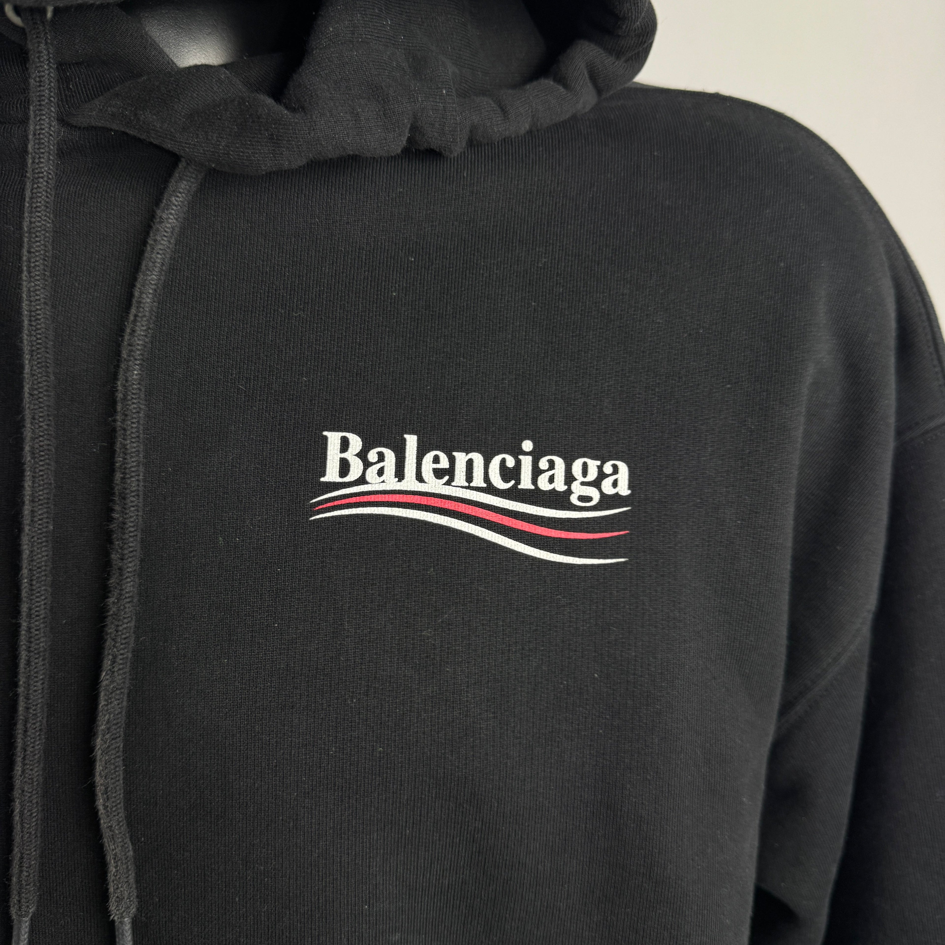 The Balenciaga Political Campaign Hoodie is a heavyweight cotton hoodie featuring the brand’s satirical “campaign” logo