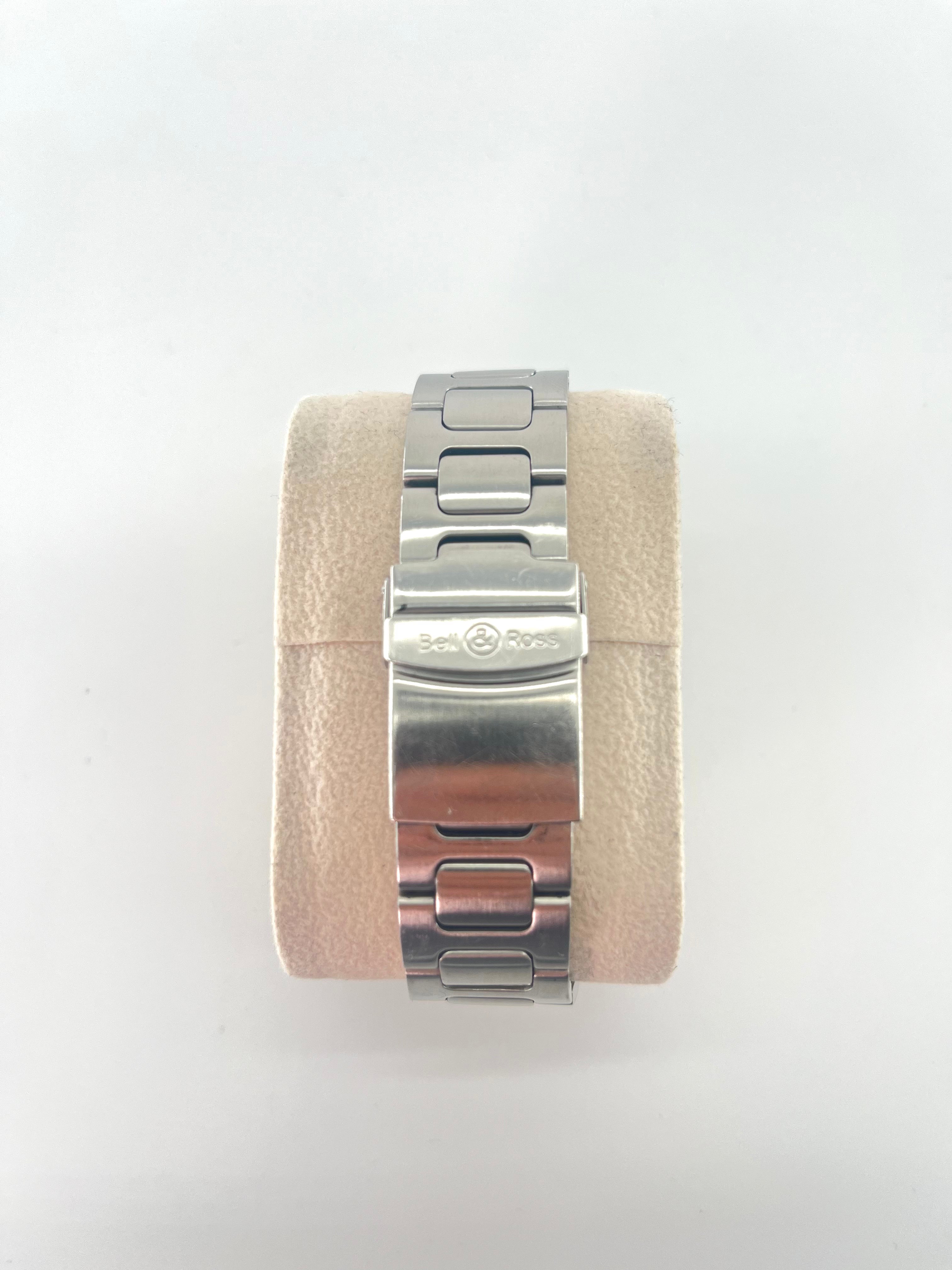 Bell and Ross Hydromax 2010 stainless steel watch bracelet on a beige velvet cushion, shown with extra watch straps on white background.
