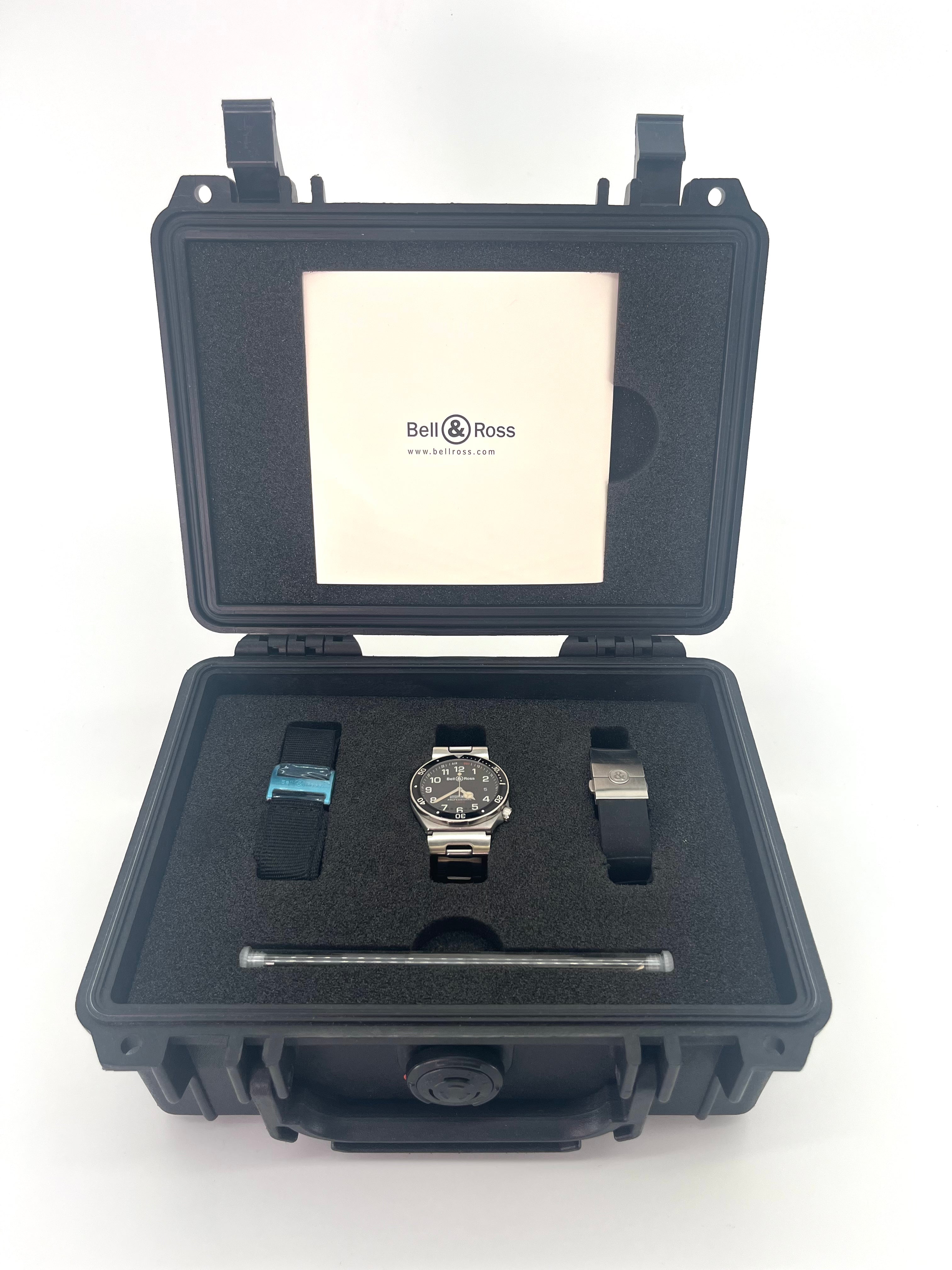 Bell & Ross watch presented in a black foam case with extra straps, a strap tool, and an instruction booklet in the lid.