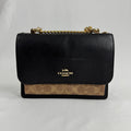 The Coach Klare Crossbody Bag is a structured leather bag with a flap closure, signature hardware, and an adjustable strap,