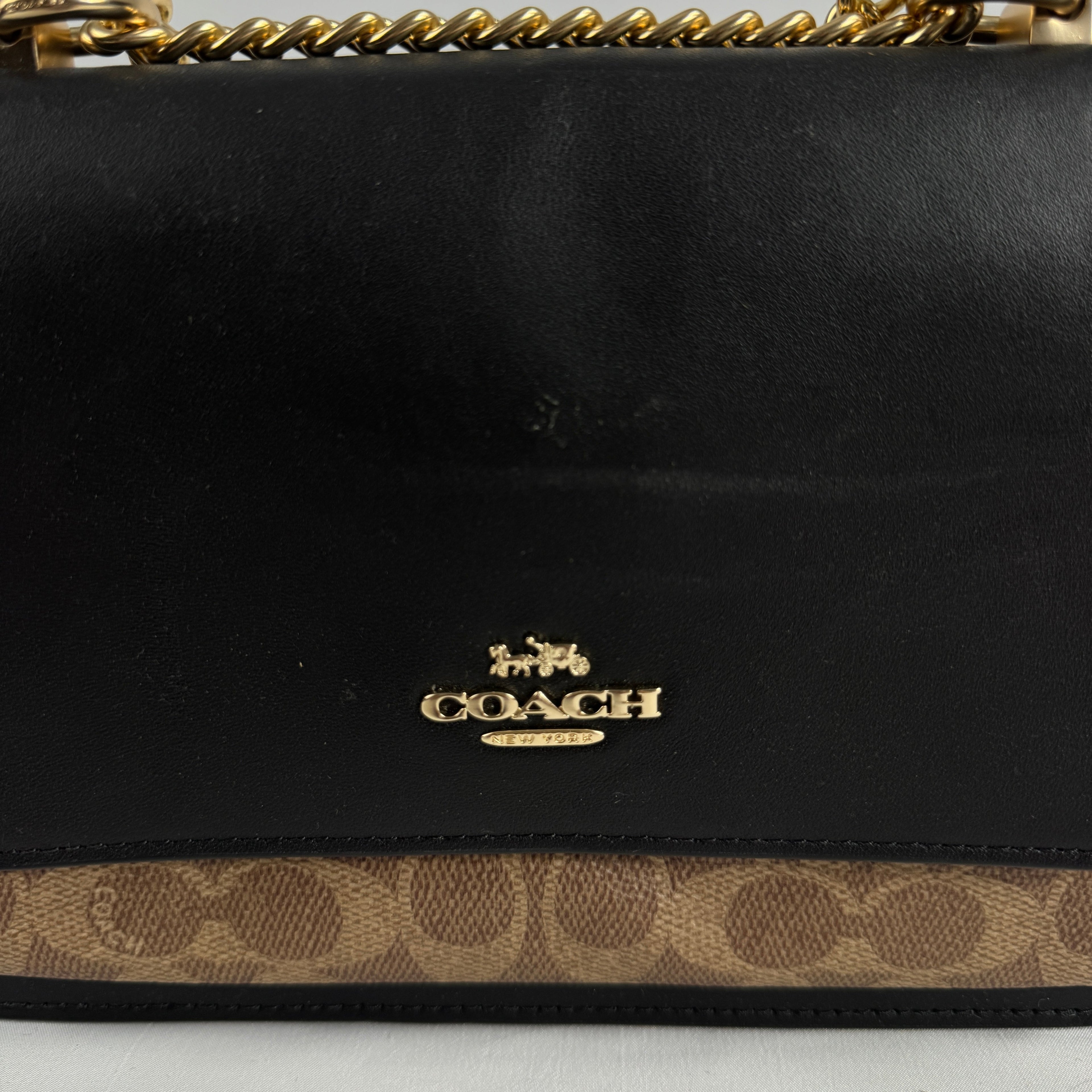 The Coach Klare Crossbody Bag is a structured leather bag with a flap closure, signature hardware, and an adjustable strap,