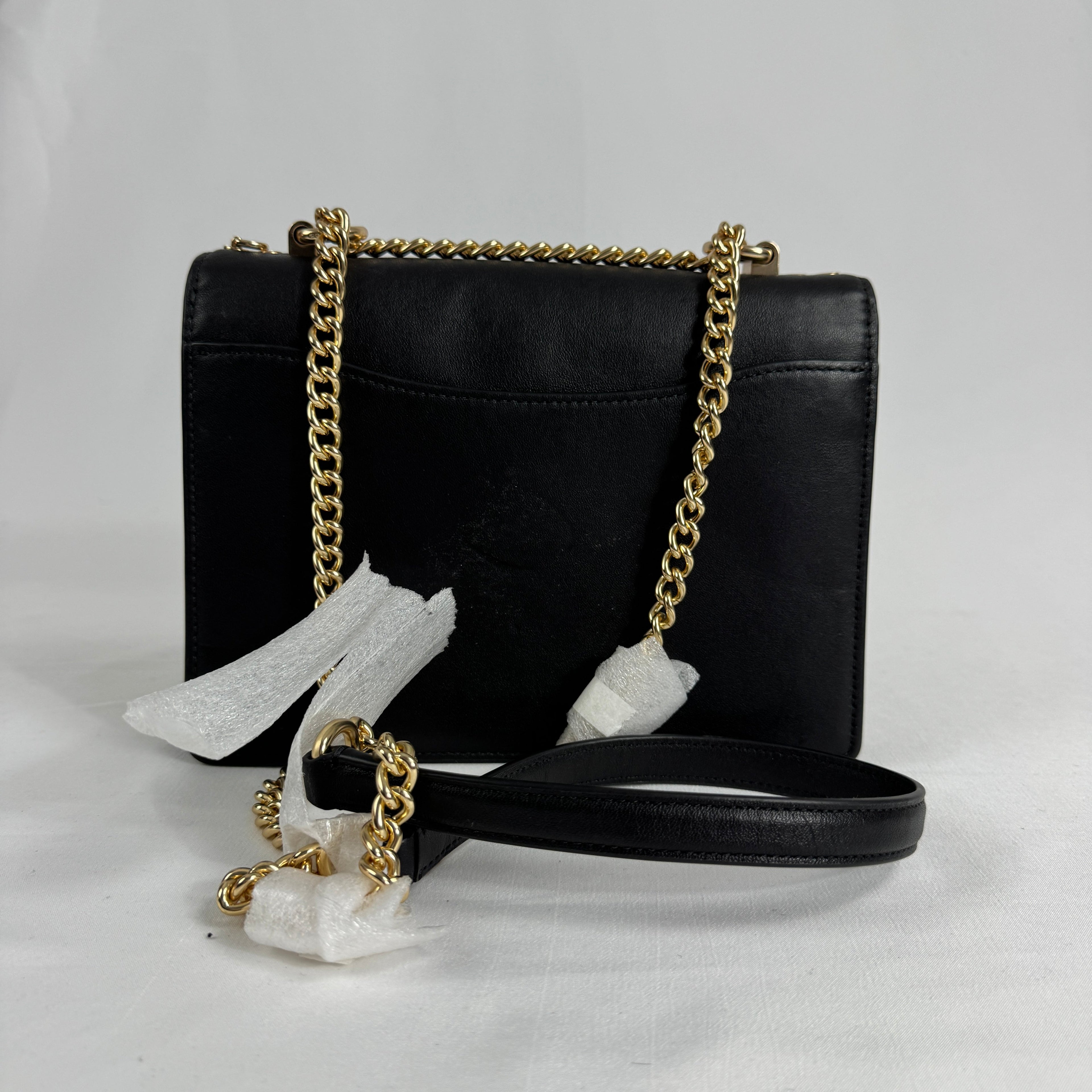 The Coach Klare Crossbody Bag is a structured leather bag with a flap closure, signature hardware, and an adjustable strap,