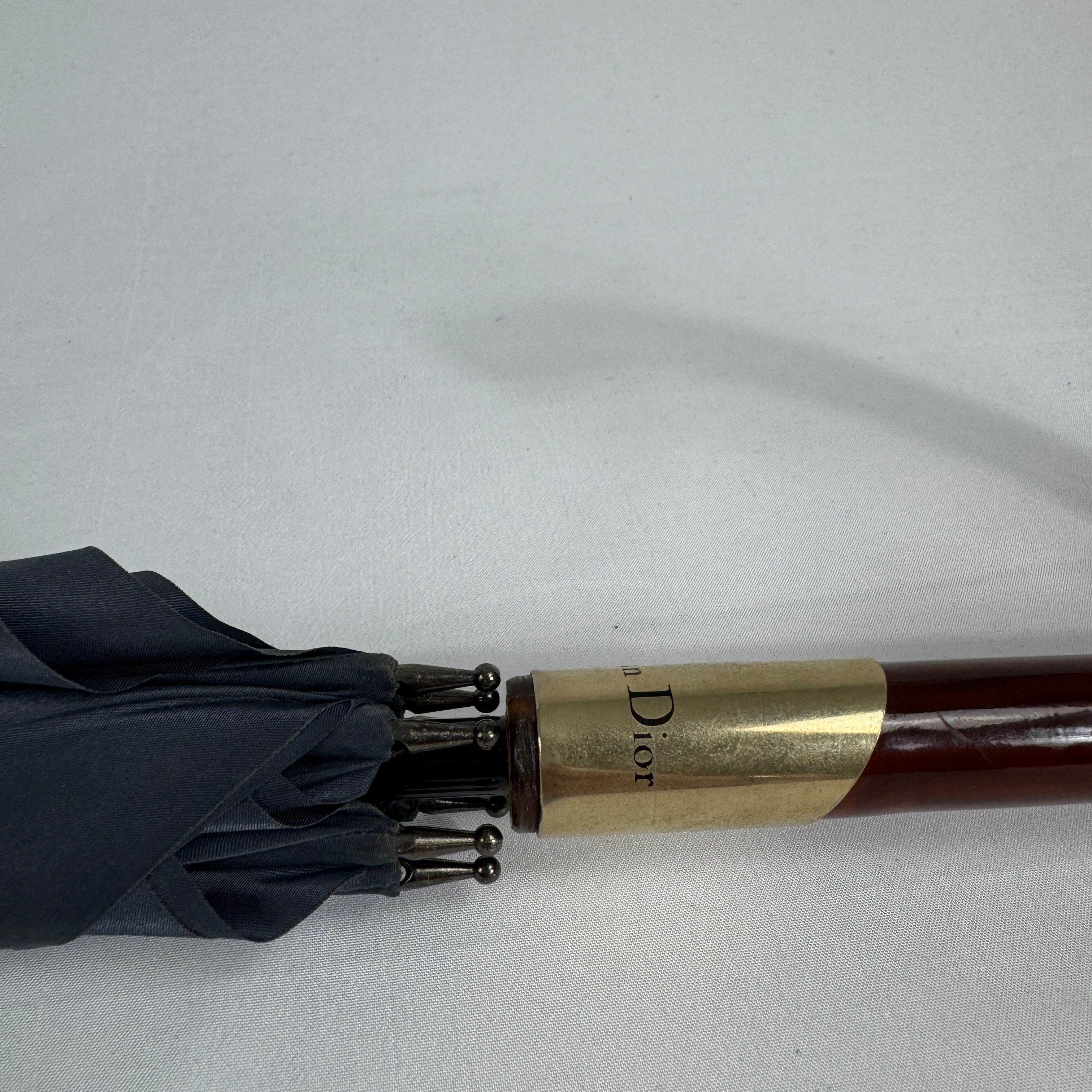 The Dior Walk’N’Dior Umbrella is a luxury rain accessory featuring signature Dior monogram detailing, a refined foldable