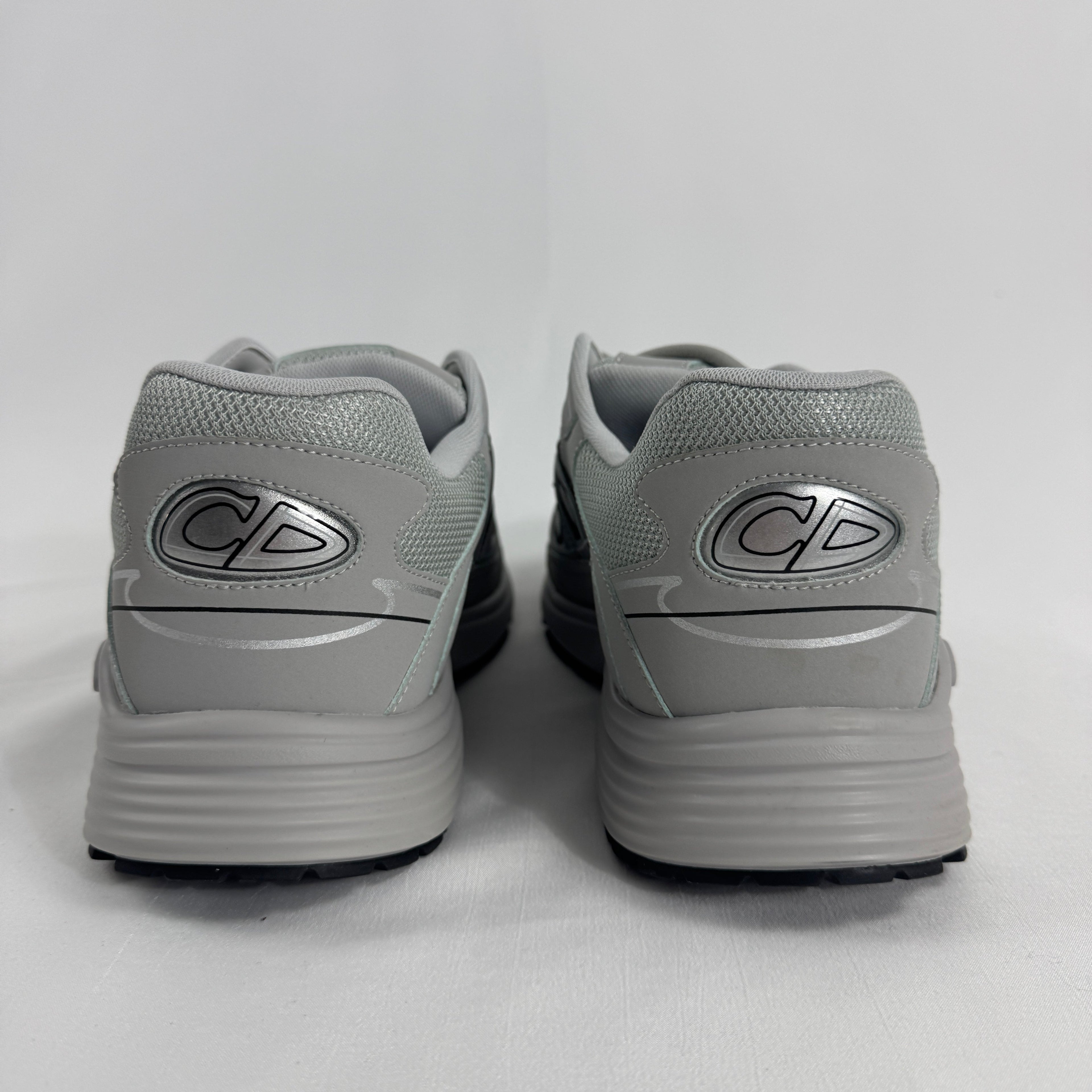 The Dior B30 Grey is a luxury sneaker featuring a technical mesh and microfiber upper in grey tones, with reflective