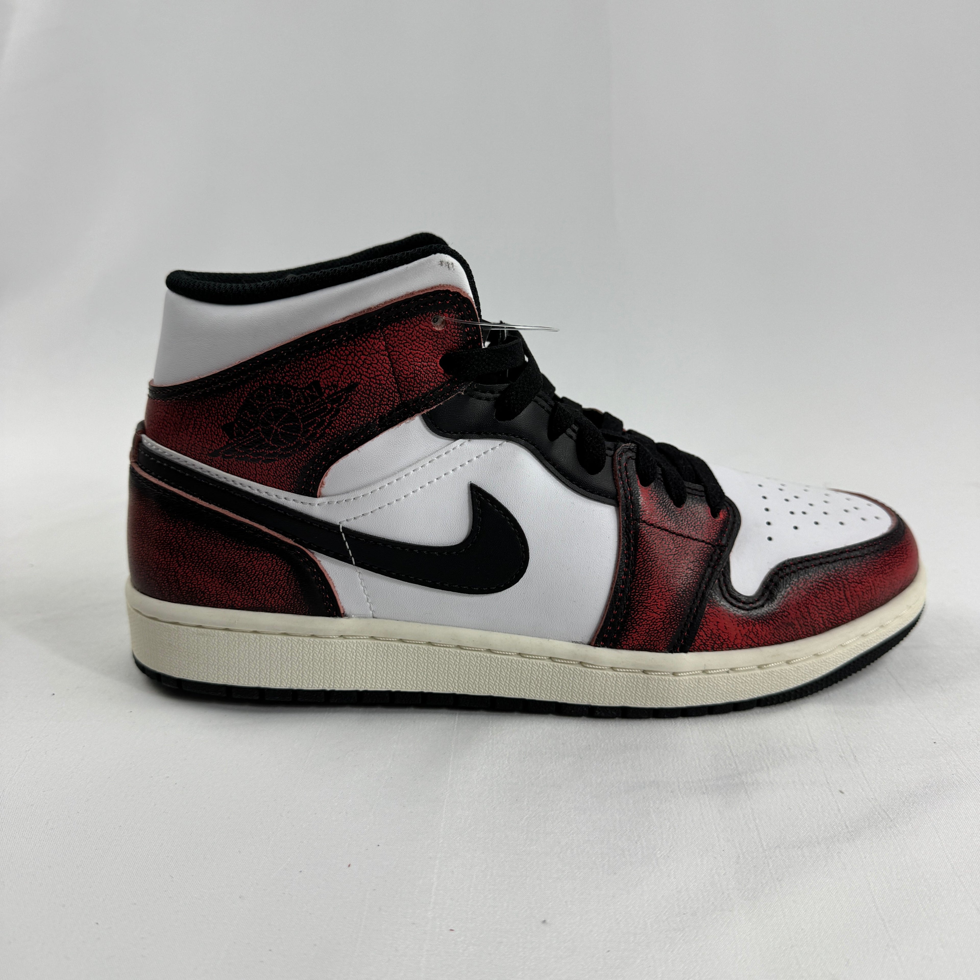 Air Jordan 1 Mid “Wear Away Chicago” is a mid-top sneaker with a white leather base and black overlays that are designed to
