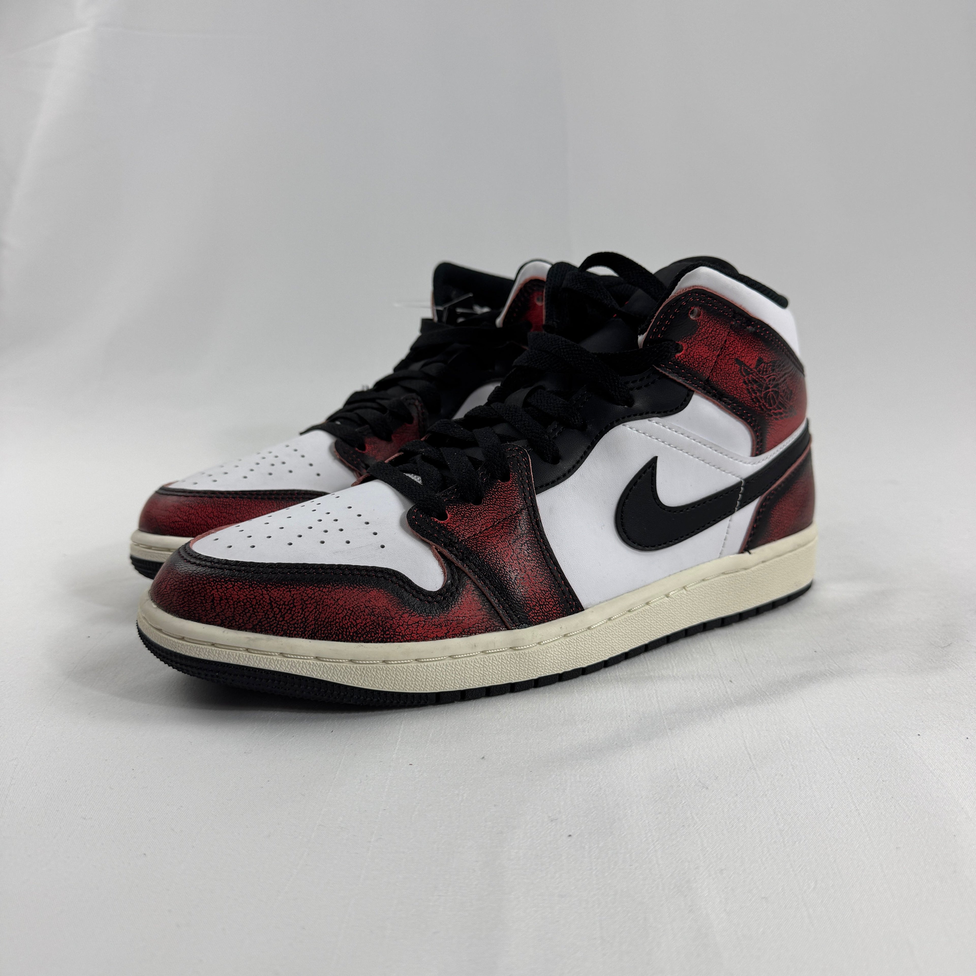 Air Jordan 1 Mid “Wear Away Chicago” is a mid-top sneaker with a white leather base and black overlays that are designed to