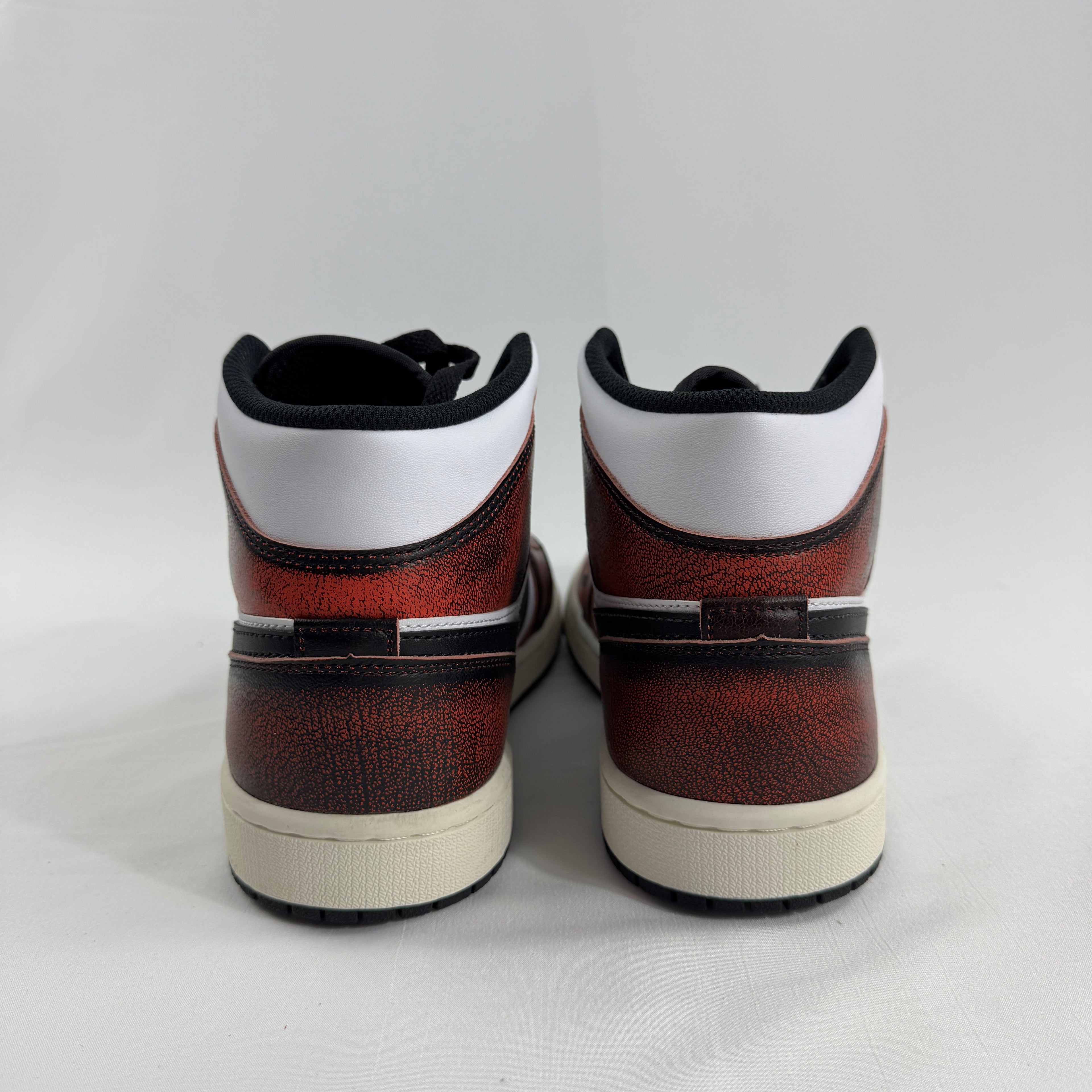 Air Jordan 1 Mid “Wear Away Chicago” is a mid-top sneaker with a white leather base and black overlays that are designed to