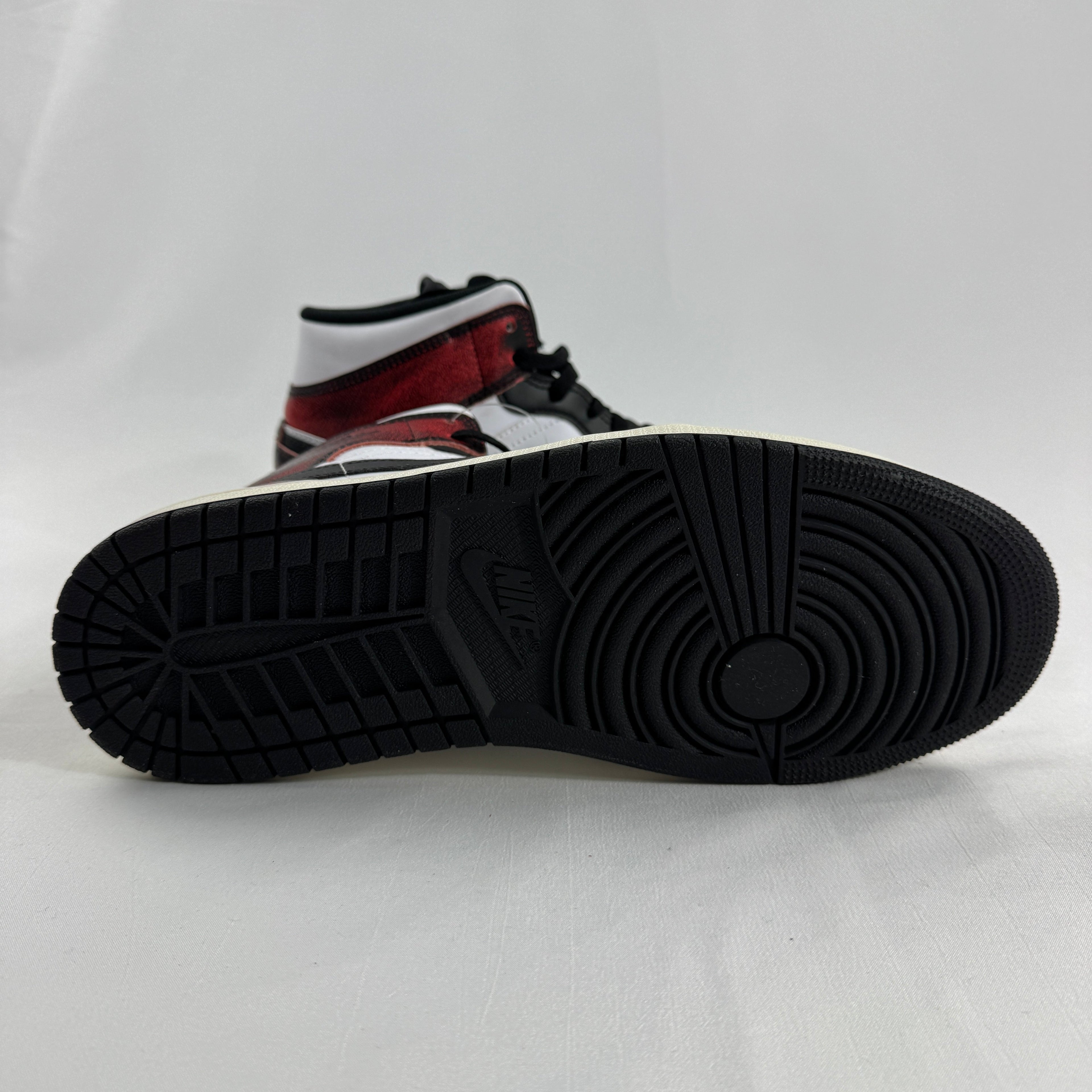 Air Jordan 1 Mid “Wear Away Chicago” is a mid-top sneaker with a white leather base and black overlays that are designed to