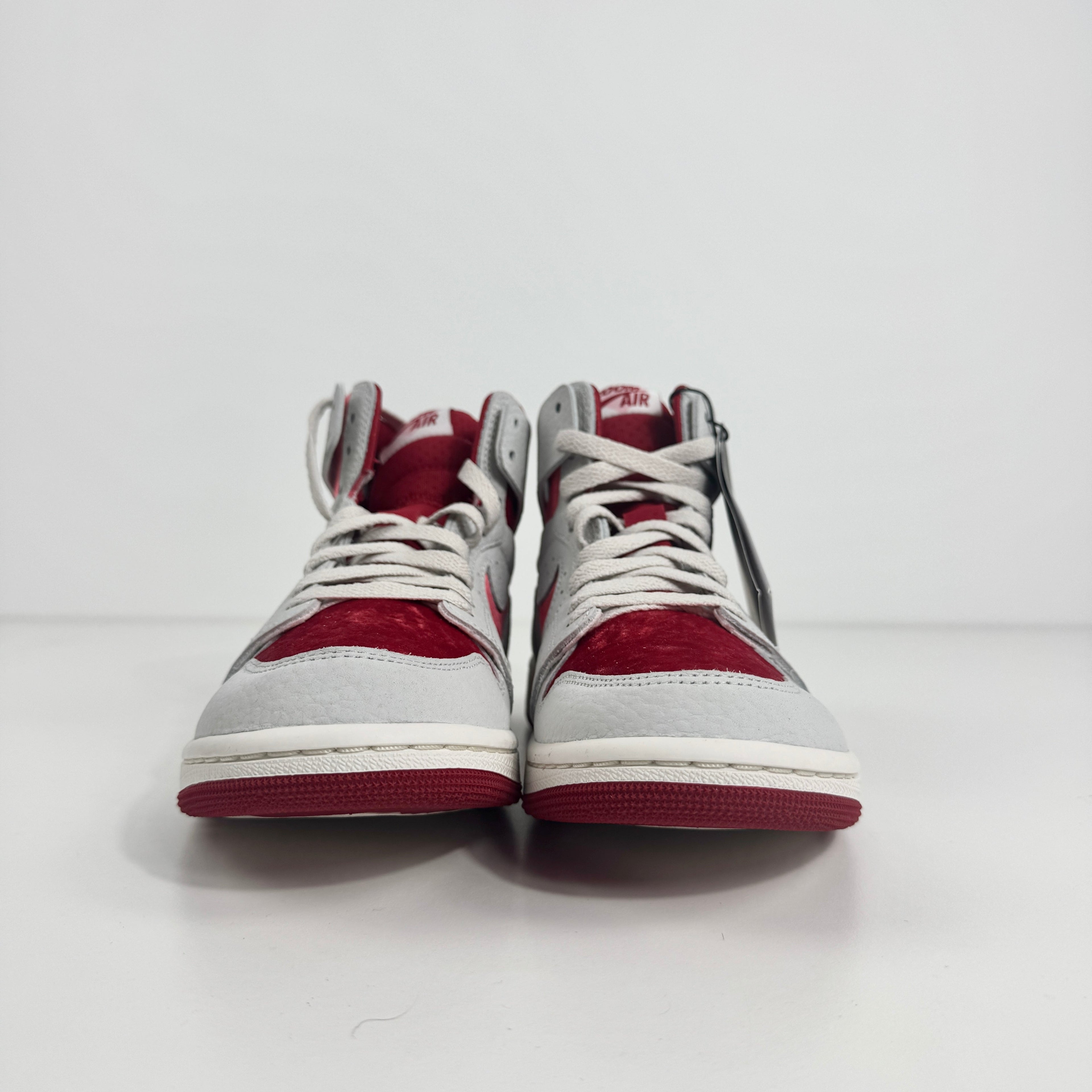 Jordan 1 Mid Zoom Grey/Red is a stylish mid-top sneaker featuring a grey upper with bold red accents for a striking look. It