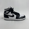 A black and white Nike high-top trainer with white laces and the Air Jordan wing logo on the collar, shown on a white background.