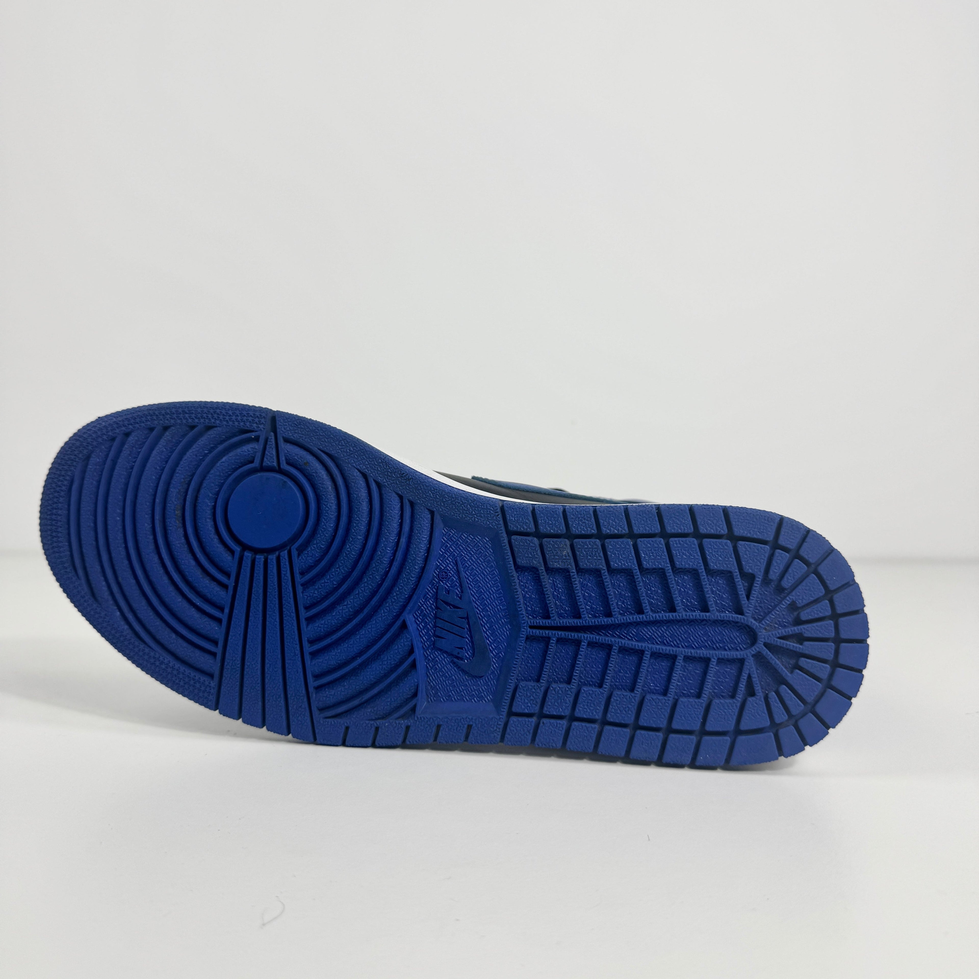 A blue trainer sole with circular and rectangular grip, Nike logo at the centre, shown sideways on a white surface.