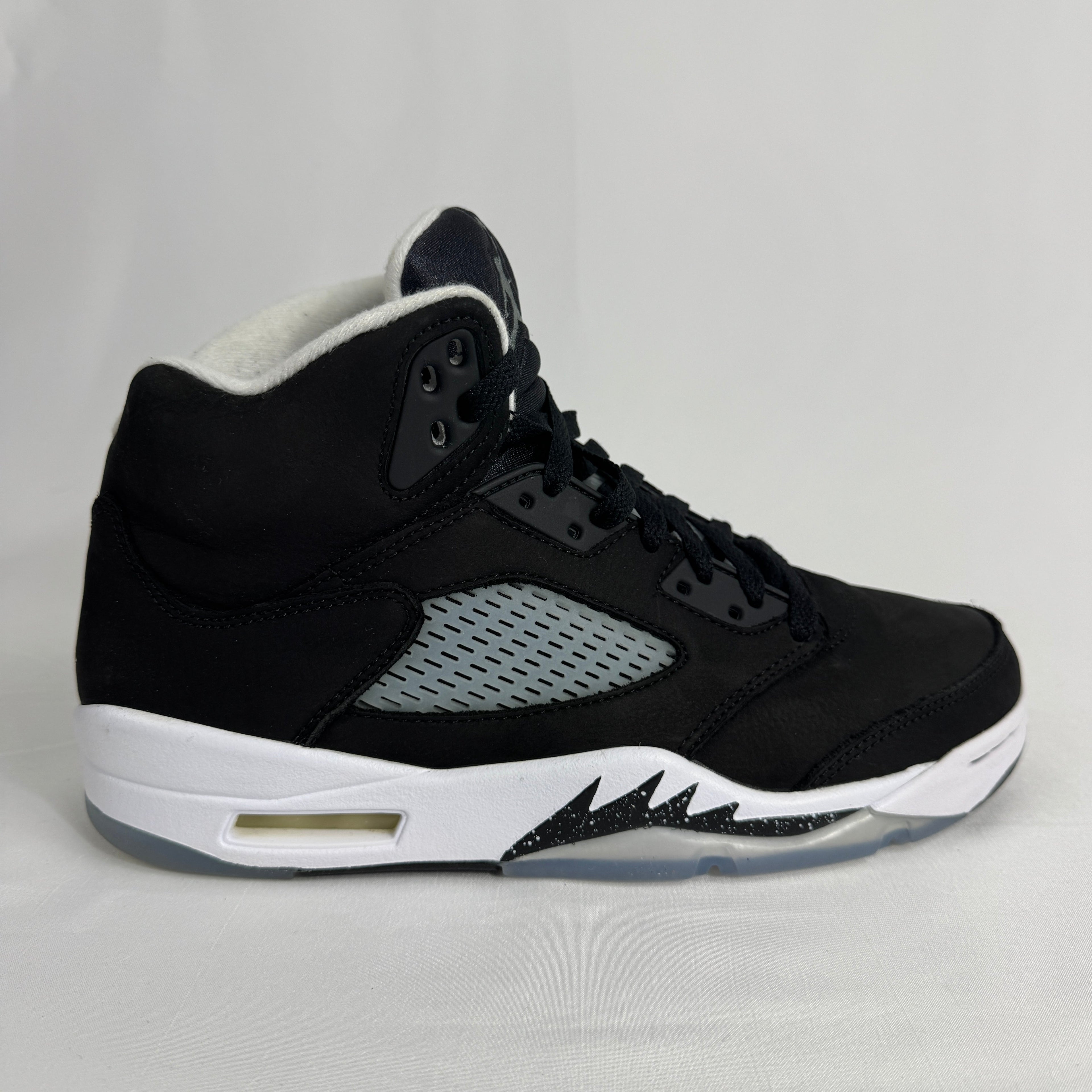 The Jordan 5 Retro Oreo is a classic basketball-inspired sneaker featuring a black nubuck upper, signature reflective