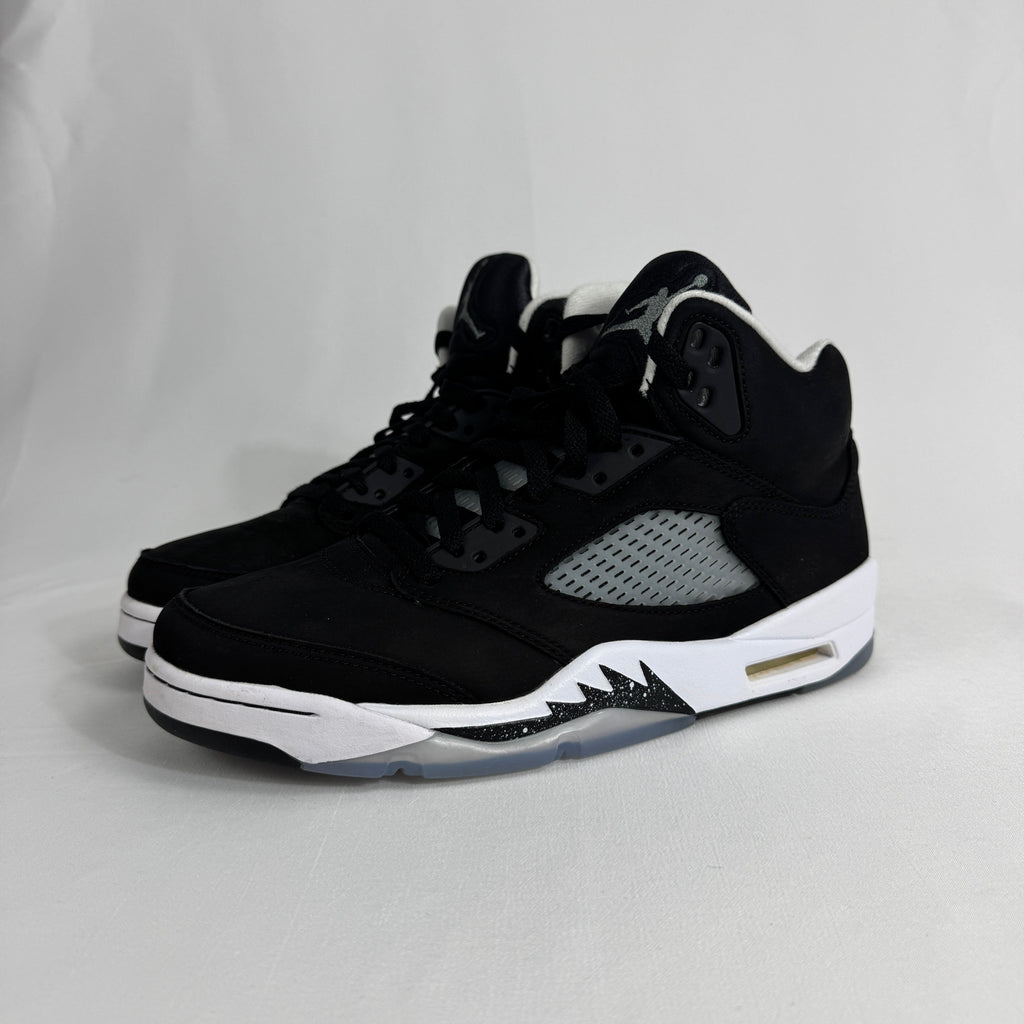 The Jordan 5 Retro Oreo is a classic basketball-inspired sneaker featuring a black nubuck upper, signature reflective