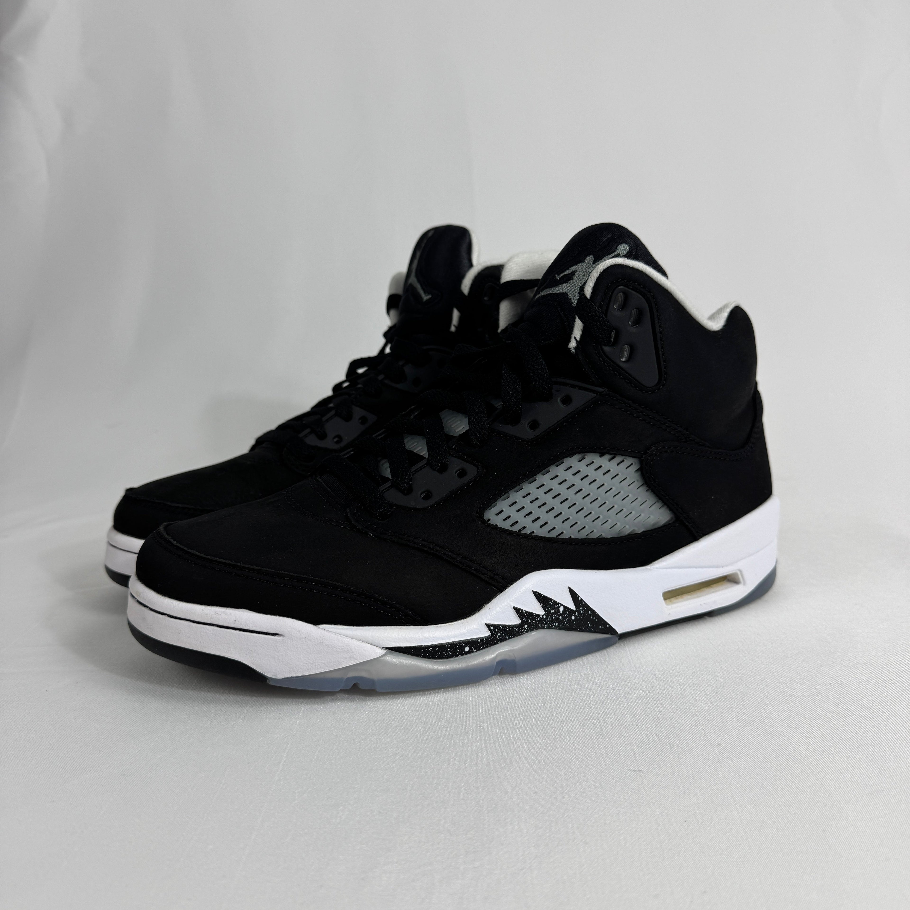 The Jordan 5 Retro Oreo is a classic basketball-inspired sneaker featuring a black nubuck upper, signature reflective