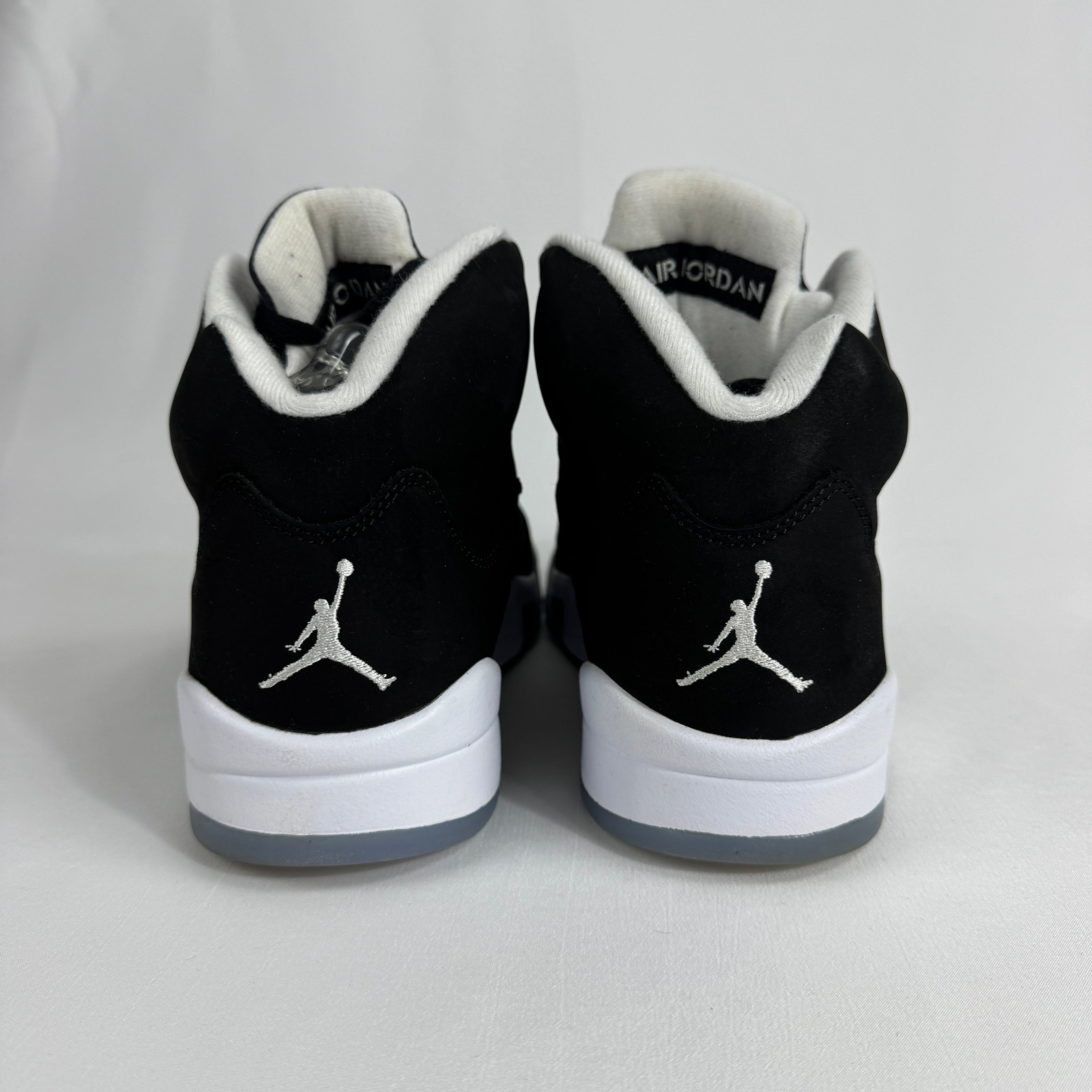 The Jordan 5 Retro Oreo is a classic basketball-inspired sneaker featuring a black nubuck upper, signature reflective