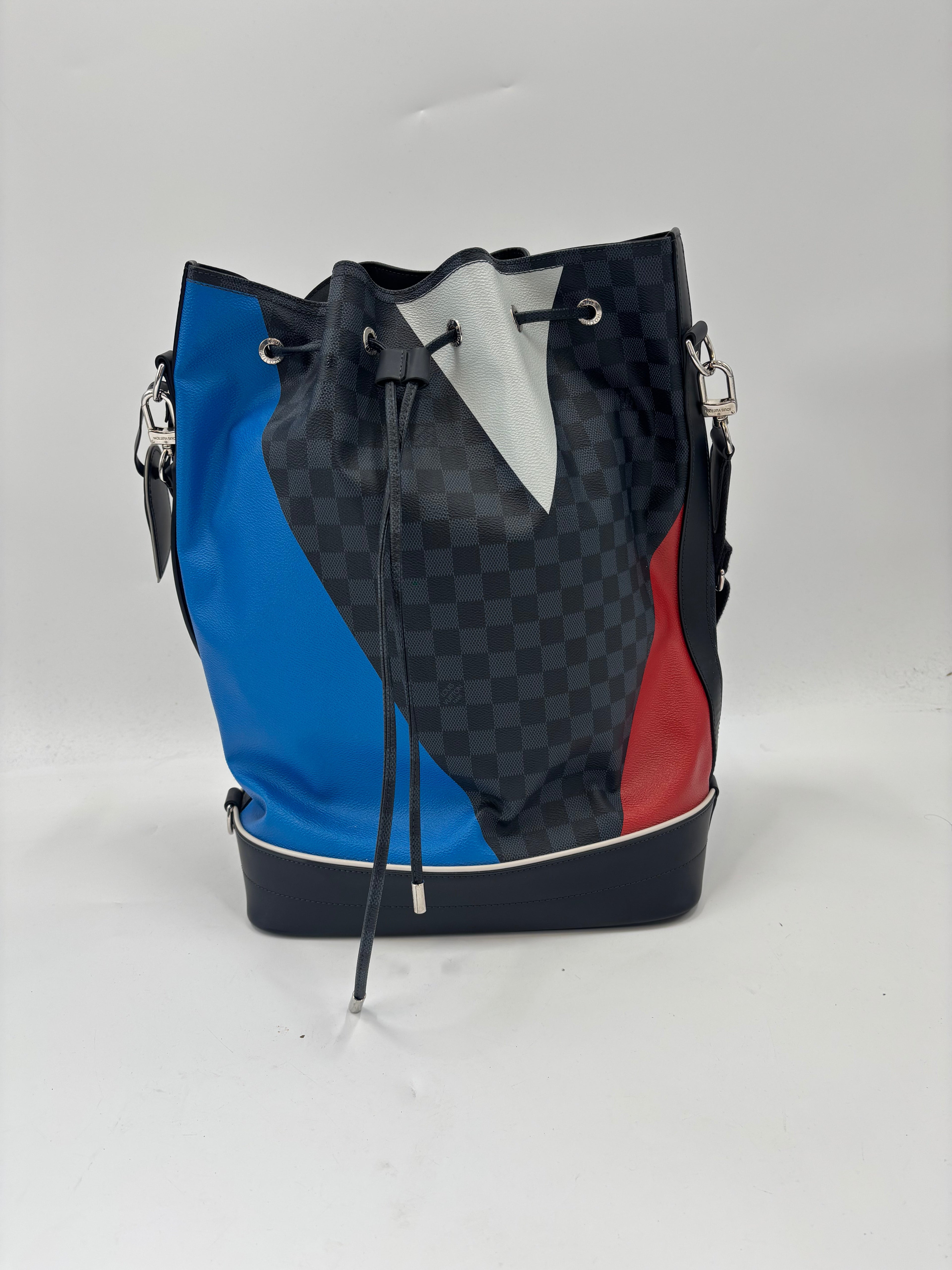 Louis Vuitton bucket bag in blue, black and grey chequered leather with red and white accents, silver hardware, and black base.