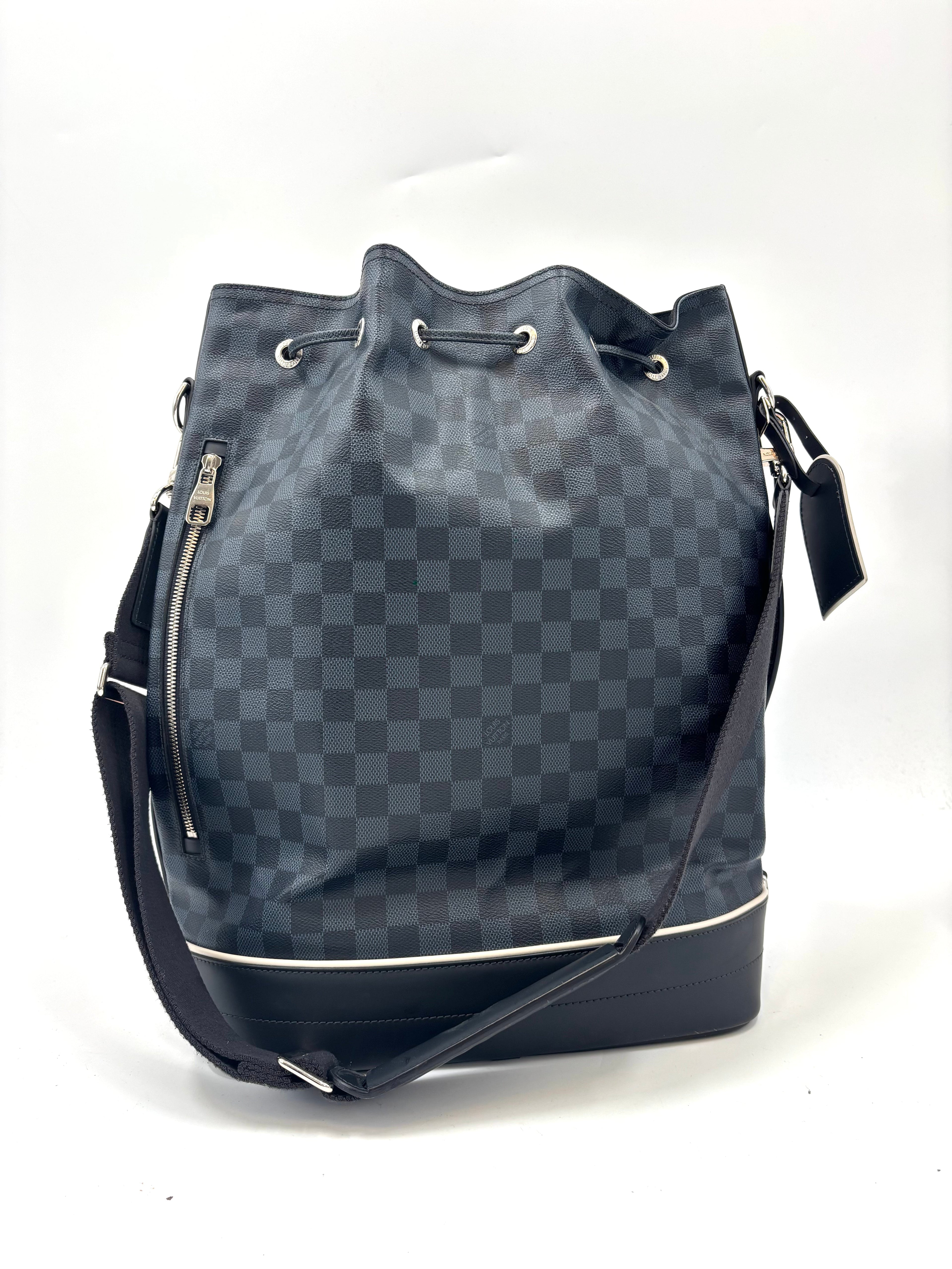 Louis Vuitton bucket bag with black and grey check pattern, drawstring closure, side zip pocket, and adjustable strap on white background.