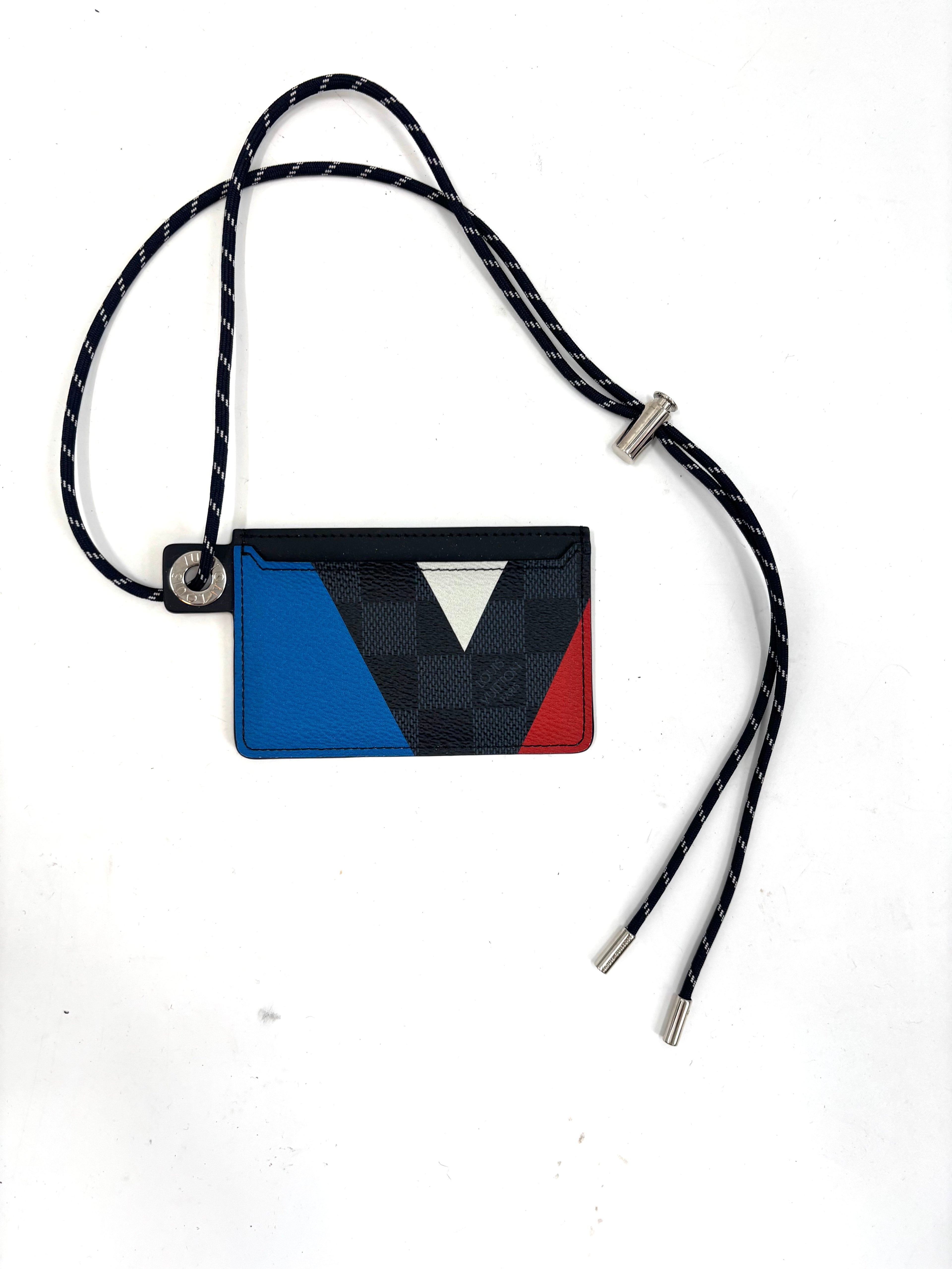 Louis Vuitton card holder with black, blue, red and white geometric design, matching lanyard and silver tips on a white background.