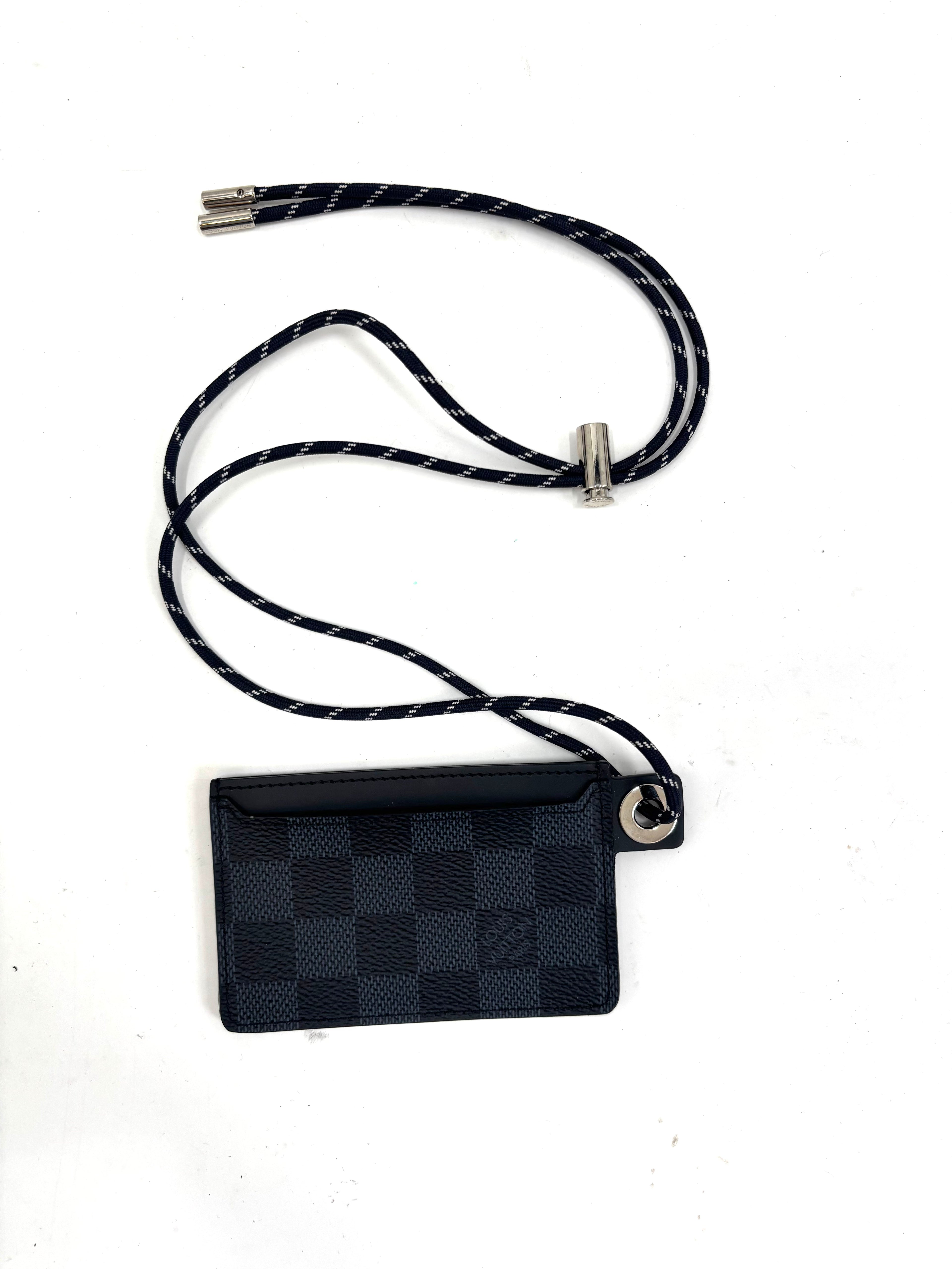 Louis Vuitton card holder with black and navy check pattern, silver hardware, and matching lanyard on a white background.