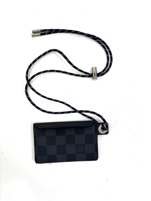 Louis Vuitton card holder with black and navy check pattern, silver hardware, and matching lanyard on a white background.
