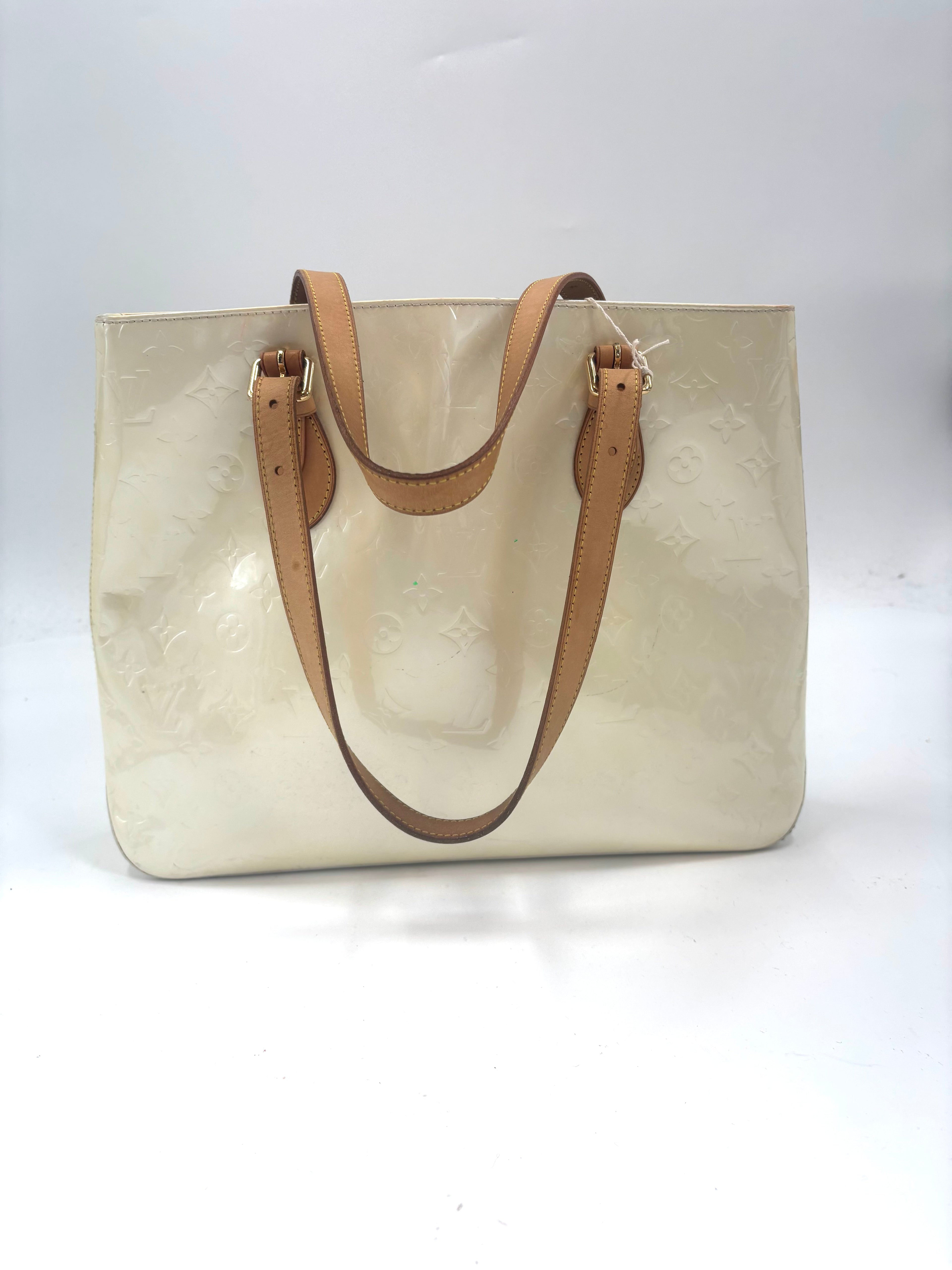 Louis Vuitton yellow handbag with tan leather shoulder straps and subtle monogram detail on a plain white background.