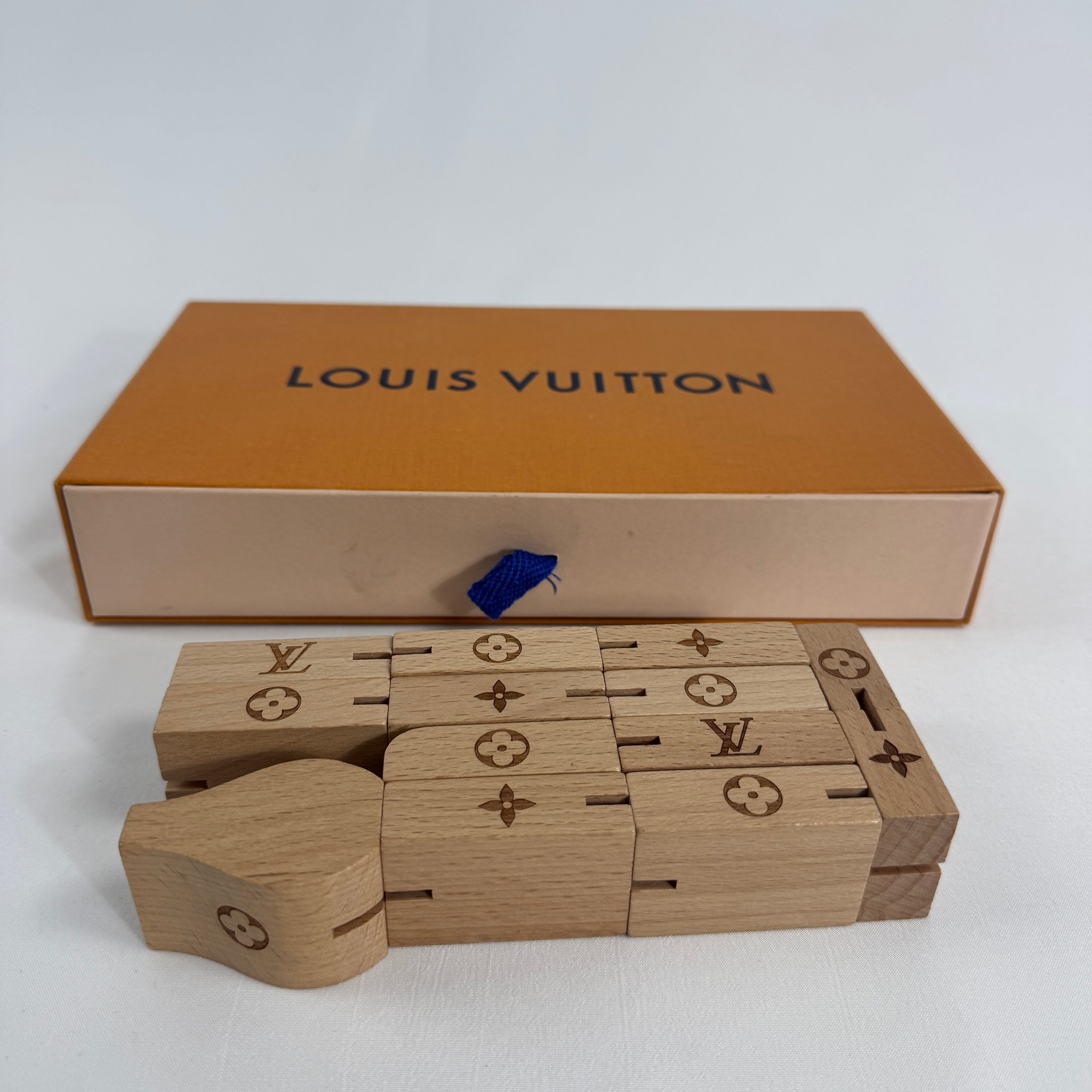 The Louis Vuitton Le Pateki Wood Puzzle is a luxury-style collectible puzzle piece featuring wooden construction and design