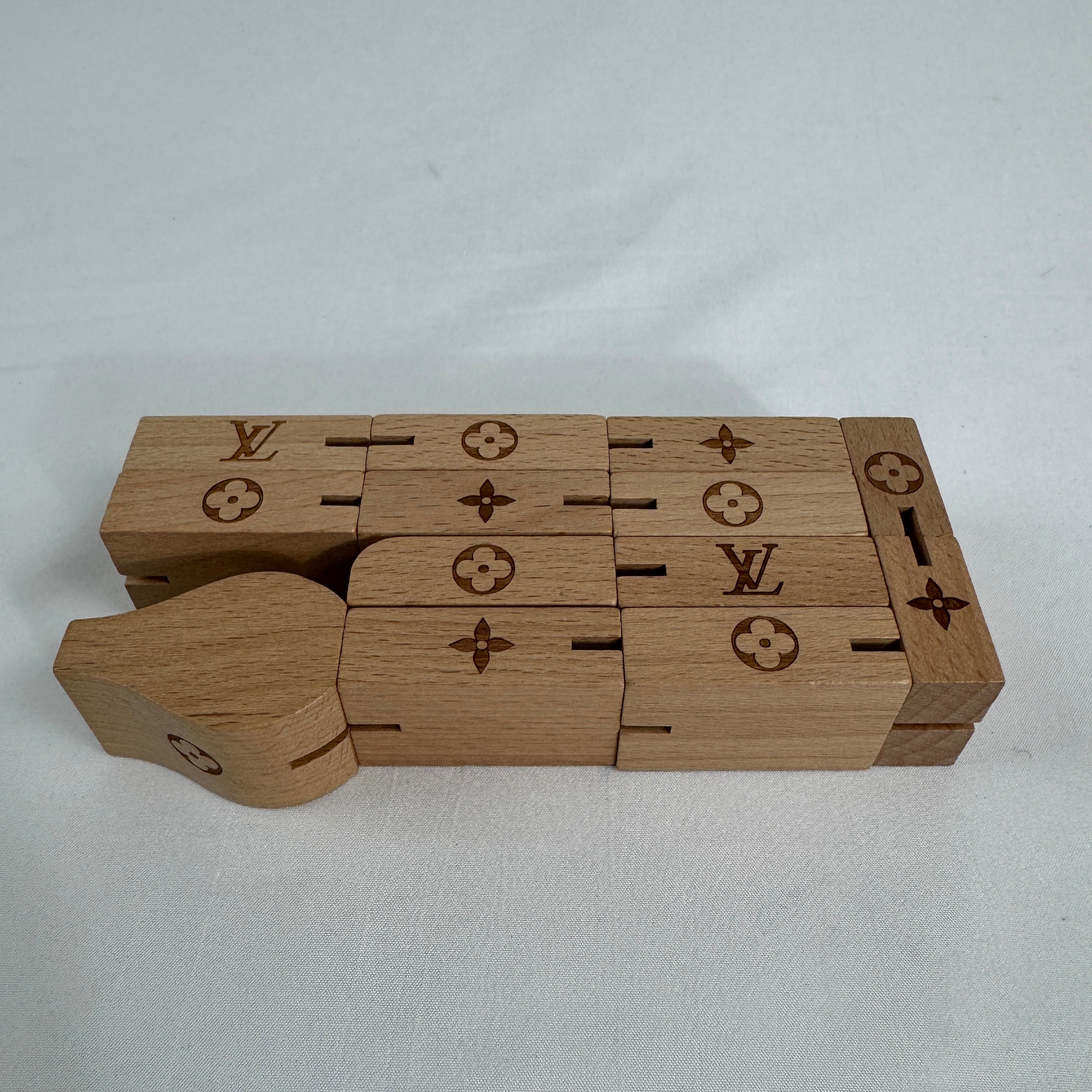 The Louis Vuitton Le Pateki Wood Puzzle is a luxury-style collectible puzzle piece featuring wooden construction and design