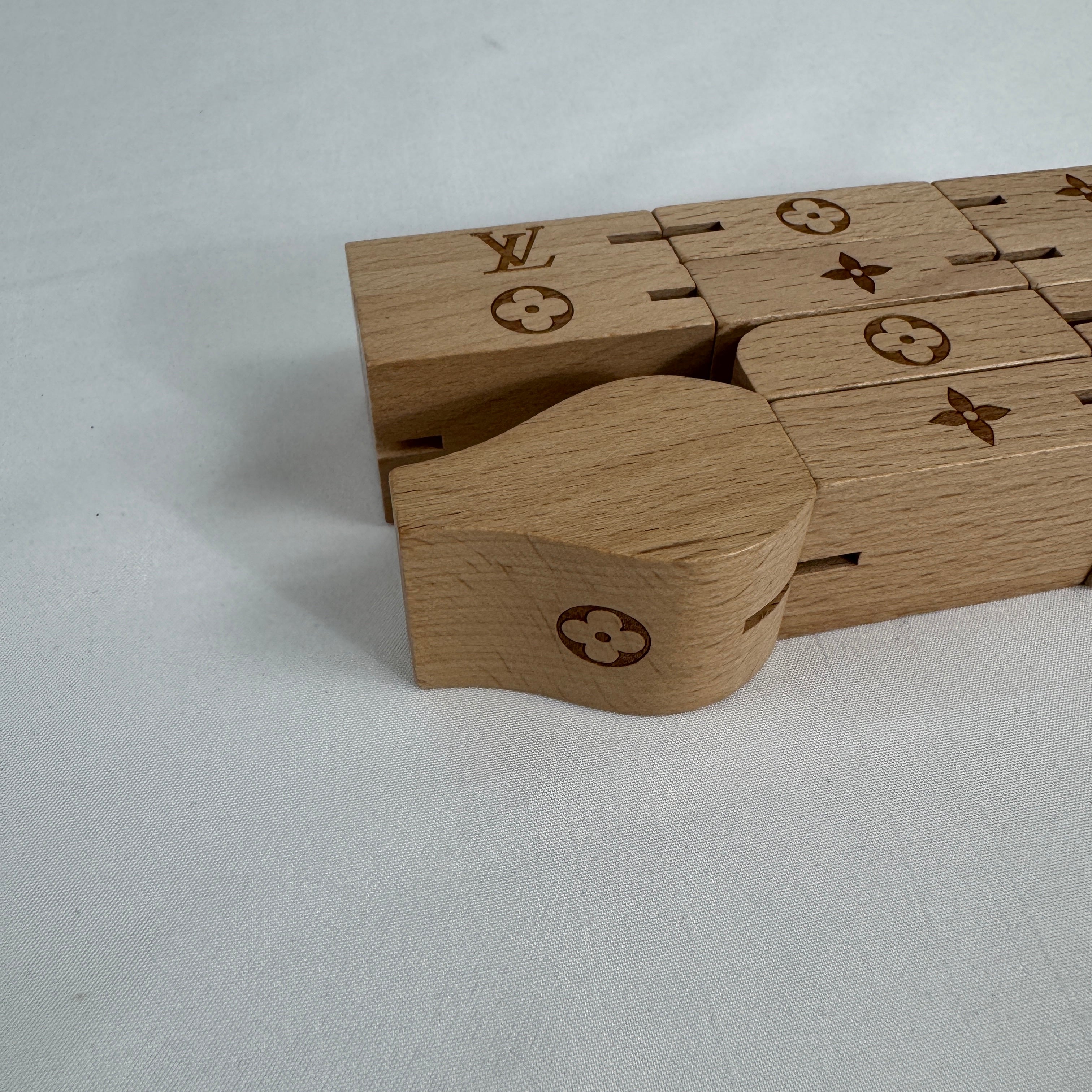 The Louis Vuitton Le Pateki Wood Puzzle is a luxury-style collectible puzzle piece featuring wooden construction and design