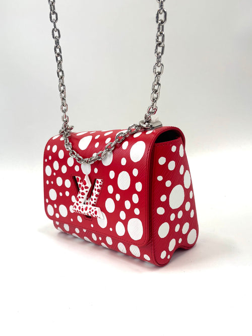 Red Louis Vuitton bag with white polka dots, silver chain strap and LV logo on the front, set against a plain white background.