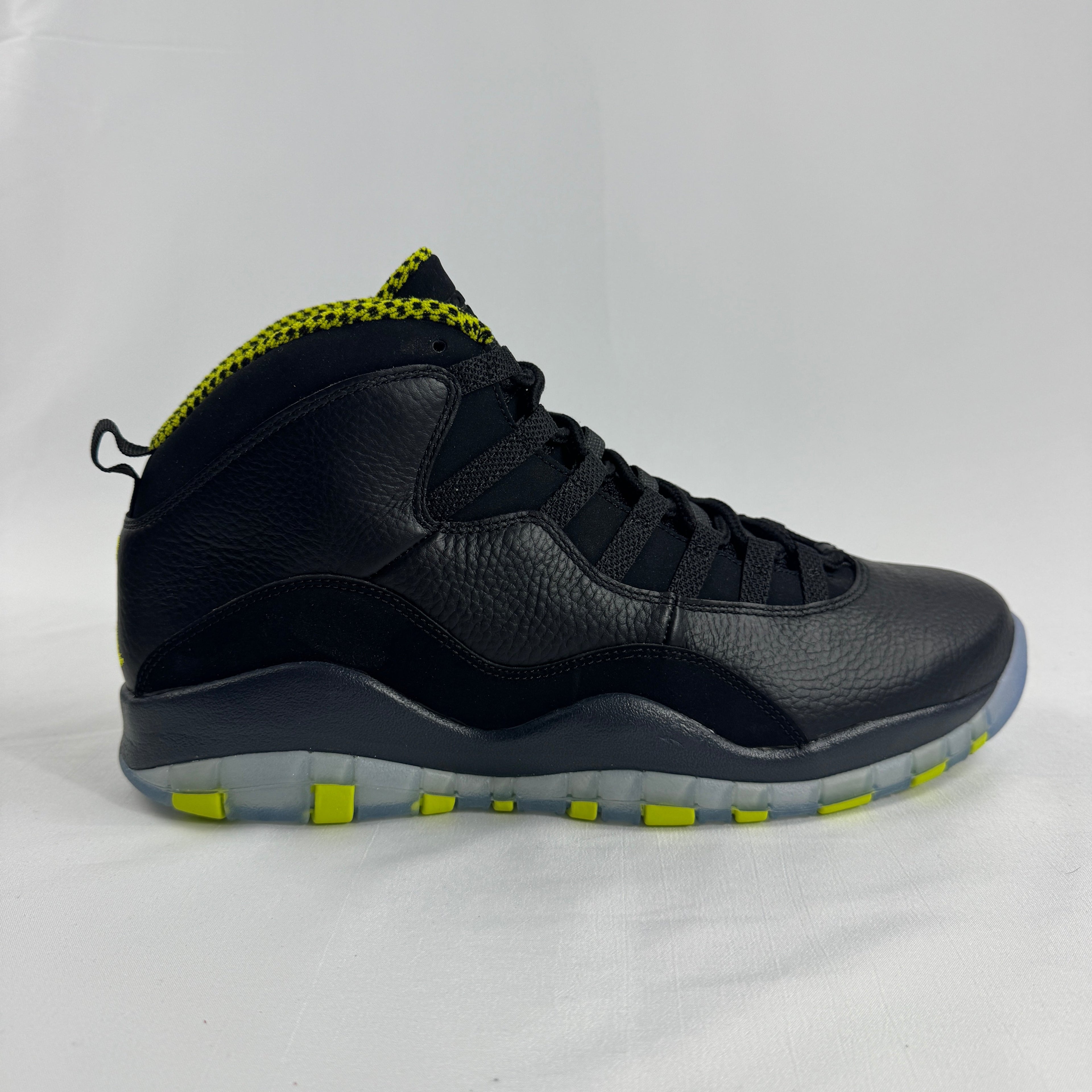 The Nike Air Jordan 10 Retro Black Venom features a sleek black tumbled leather upper paired with vibrant Venom Green
