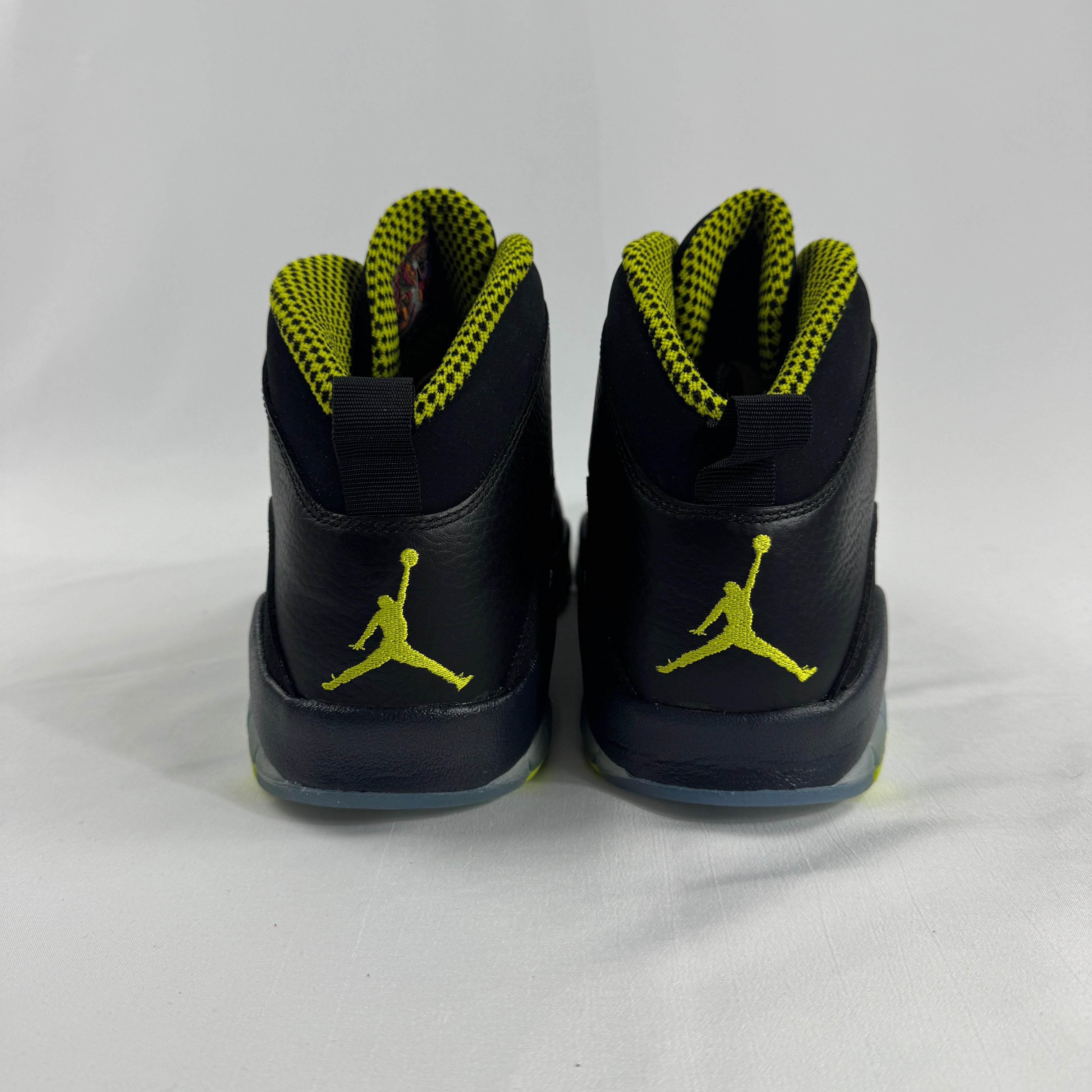 The Nike Air Jordan 10 Retro Black Venom features a sleek black tumbled leather upper paired with vibrant Venom Green
